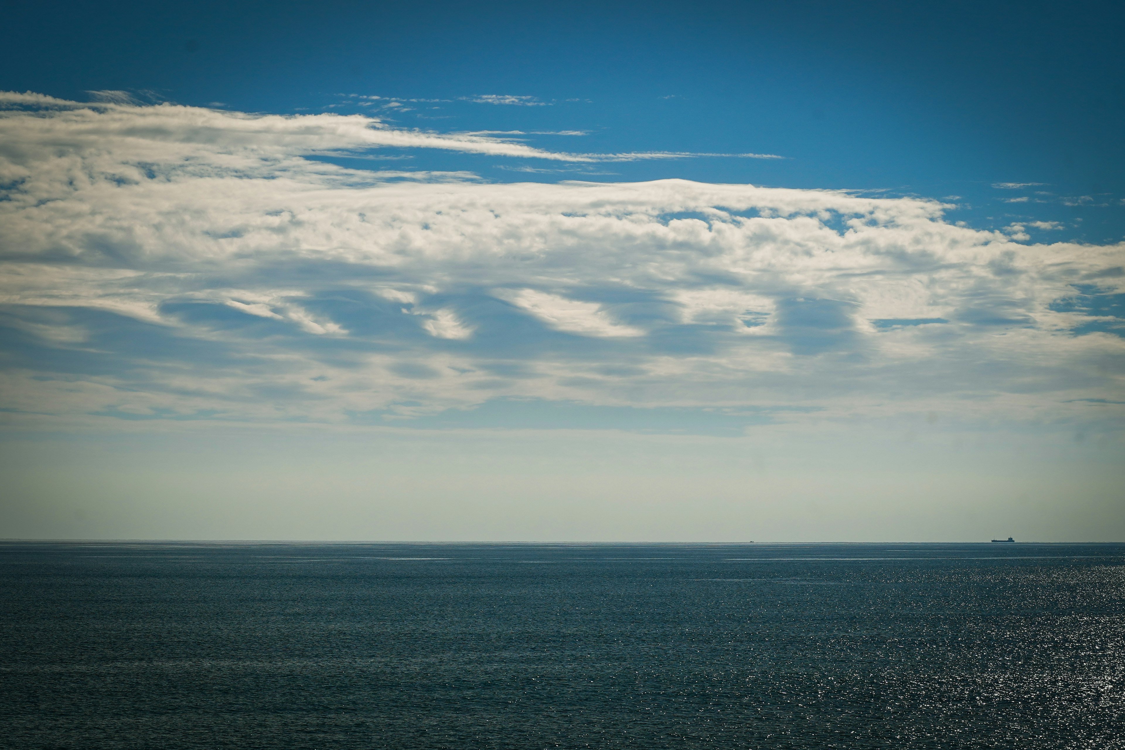 青い空と白い雲が広がる海の風景