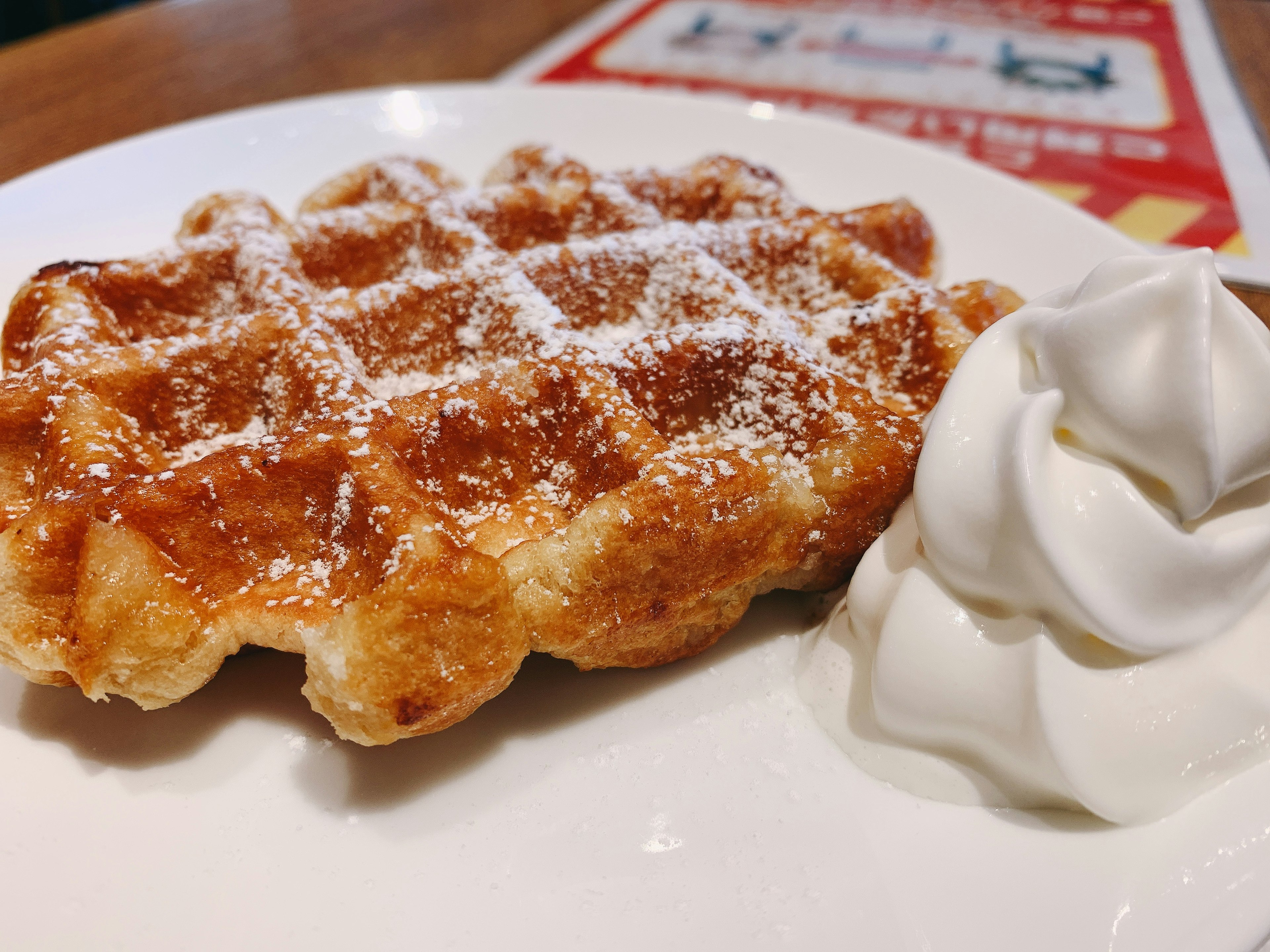 Delicious sweet waffle with whipped cream on the side