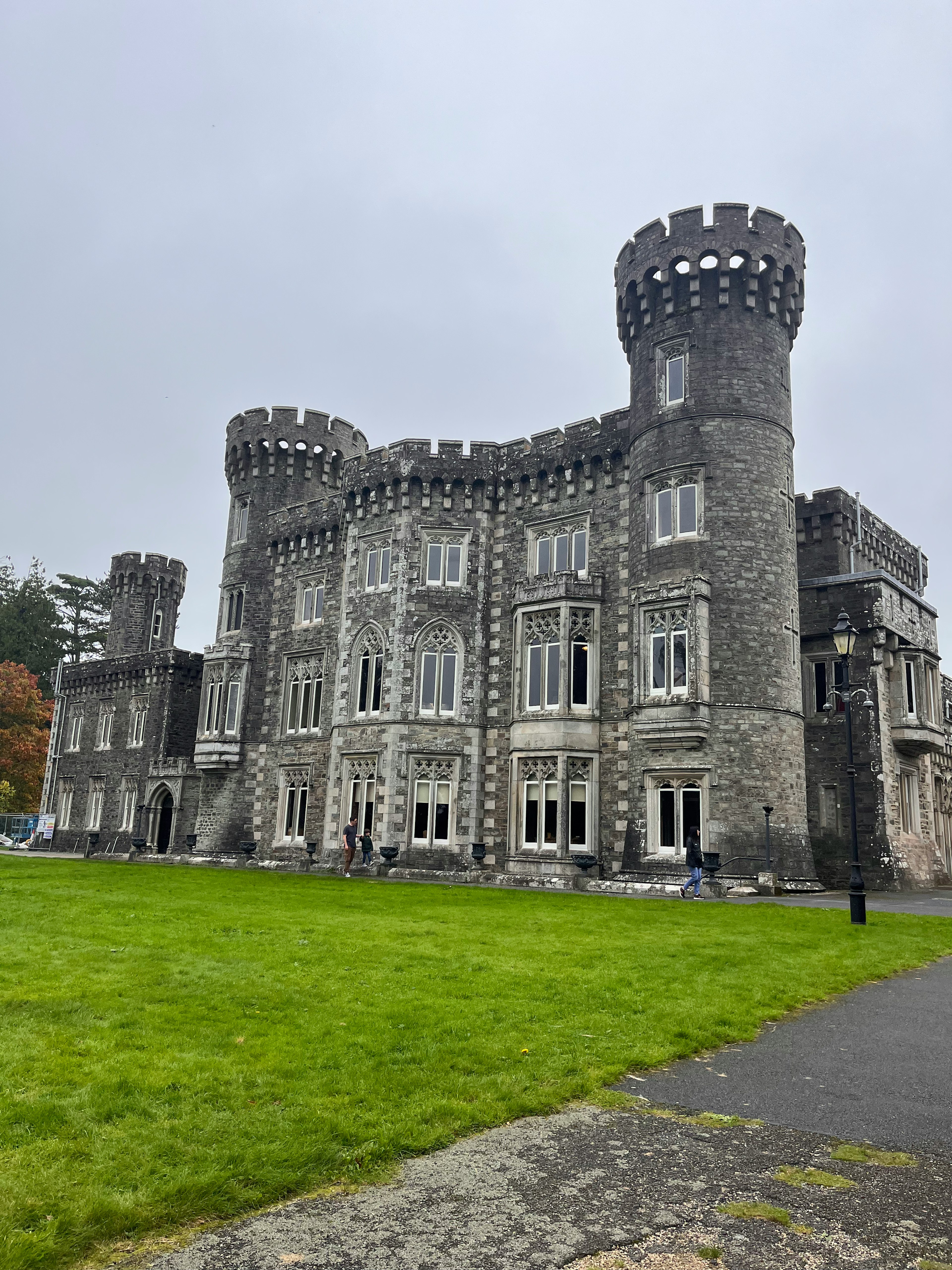 Château en pierre grise avec des tours distinctives grandes fenêtres et extérieur spacieux