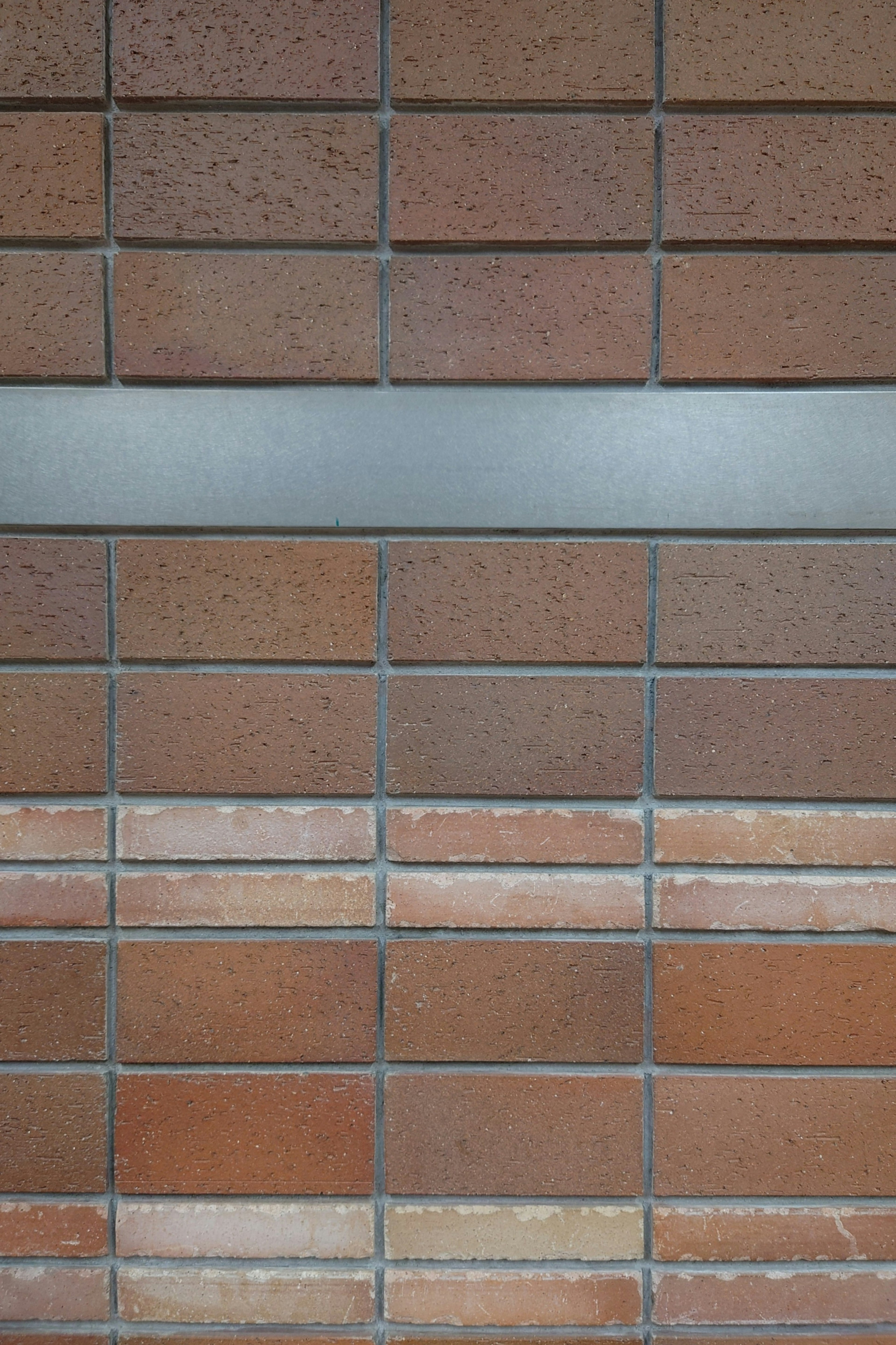 Brick wall design with a horizontal metal strip