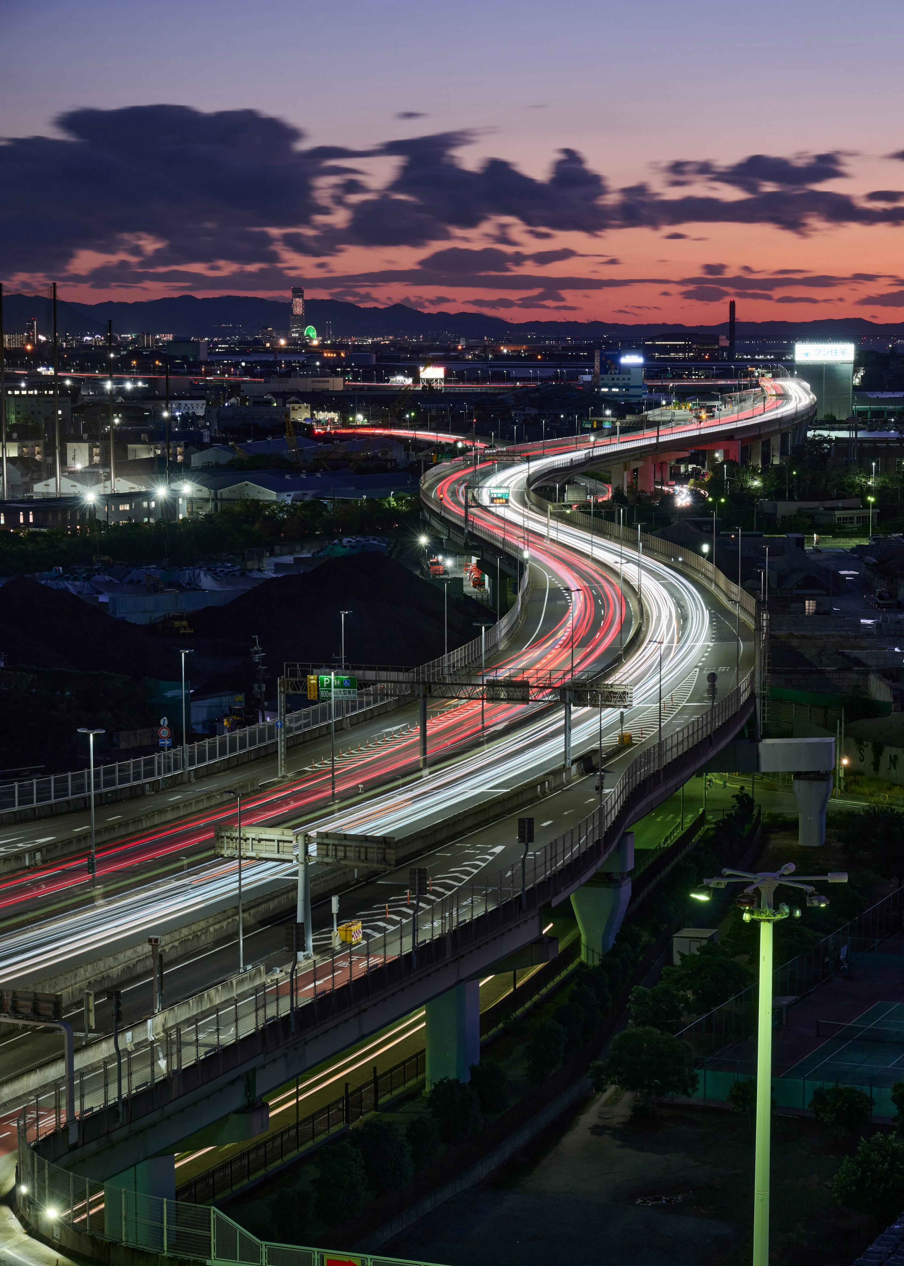 Route sinueuse avec des traînées de lumière au crépuscule