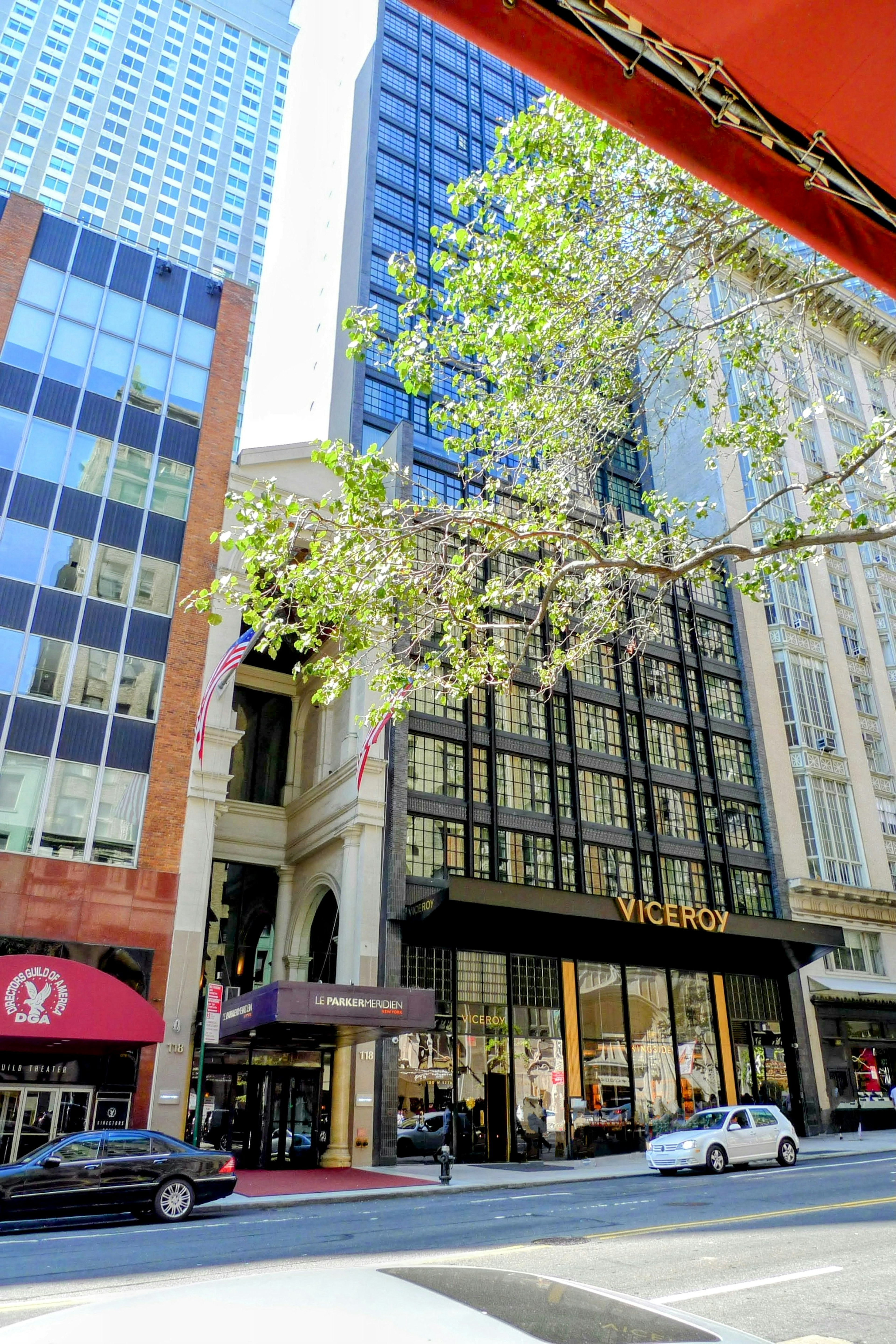 Vue de rue avec le magasin Victoria entouré de grands bâtiments et d'arbres verts