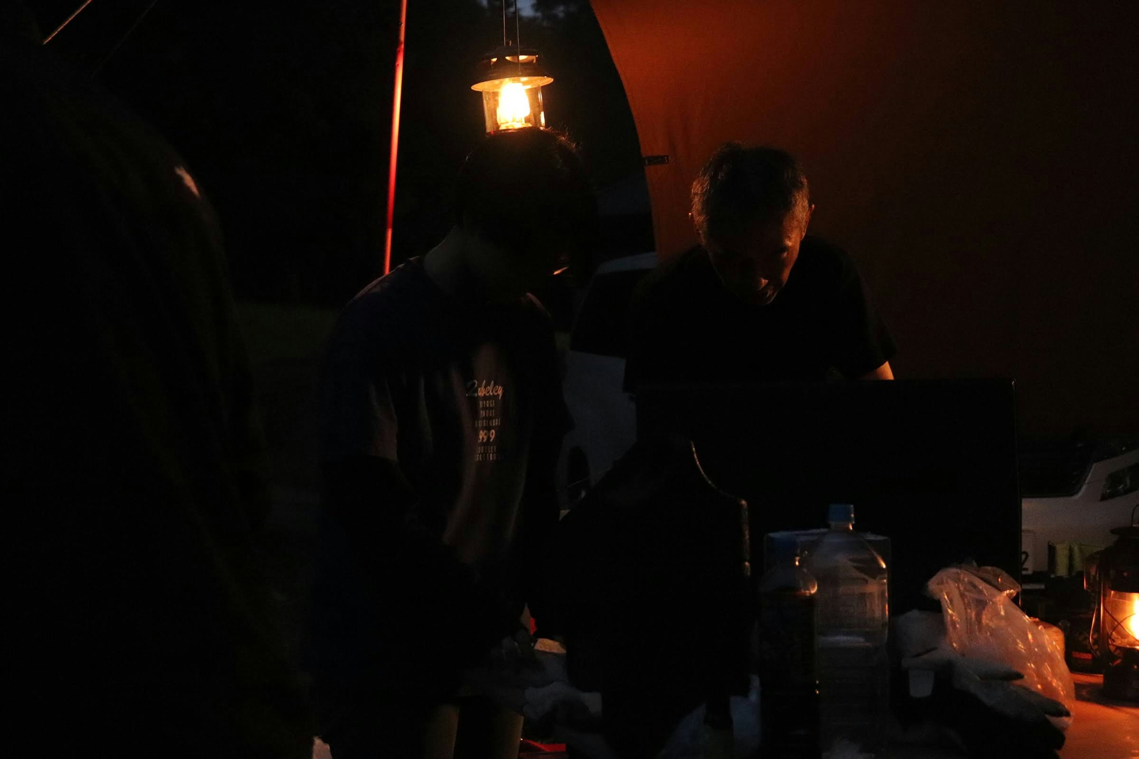 Personas trabajando alrededor de una fogata con luz de linterna