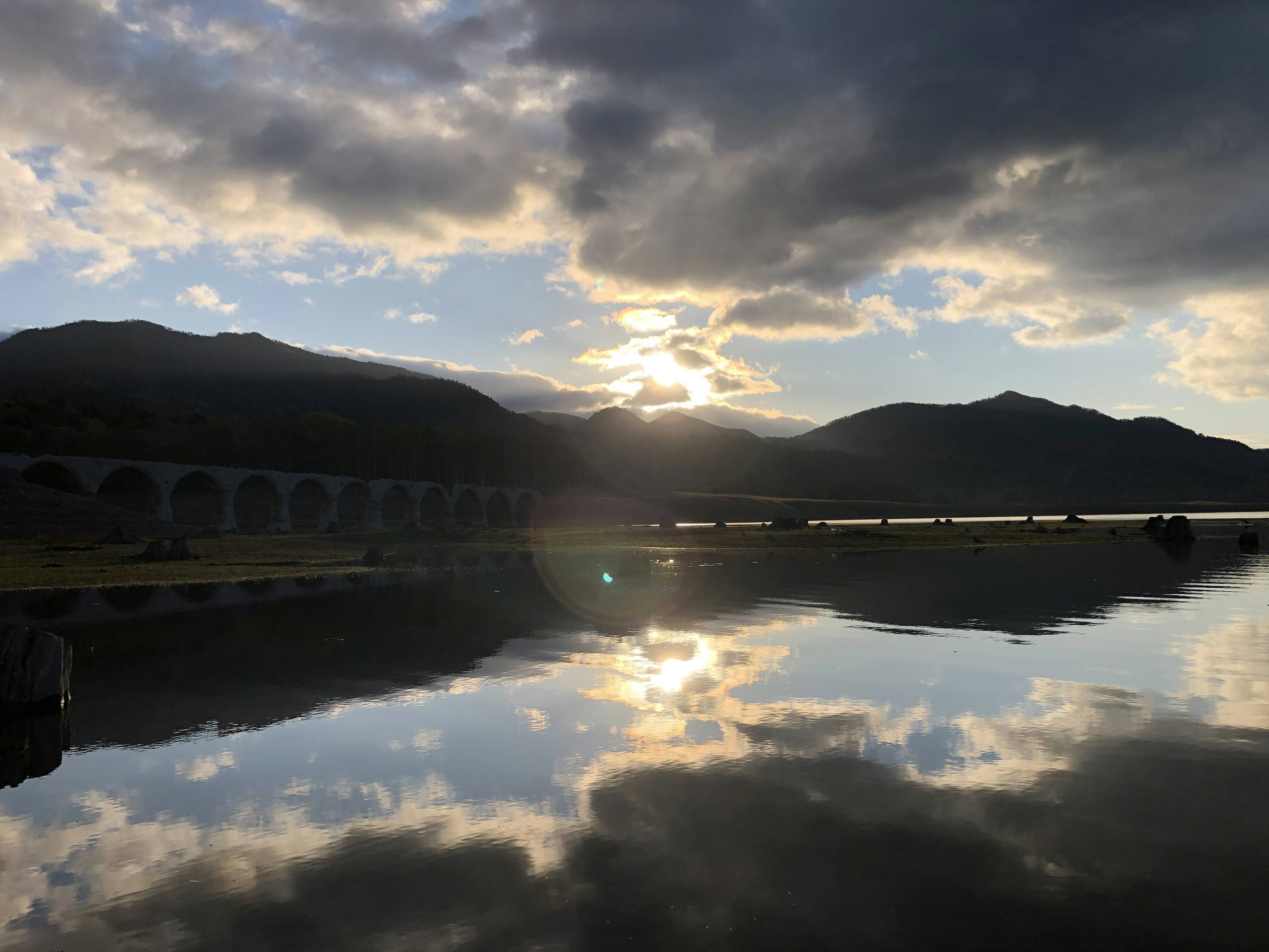 美丽的湖泊风景与山和云的倒影夕阳从山间透出