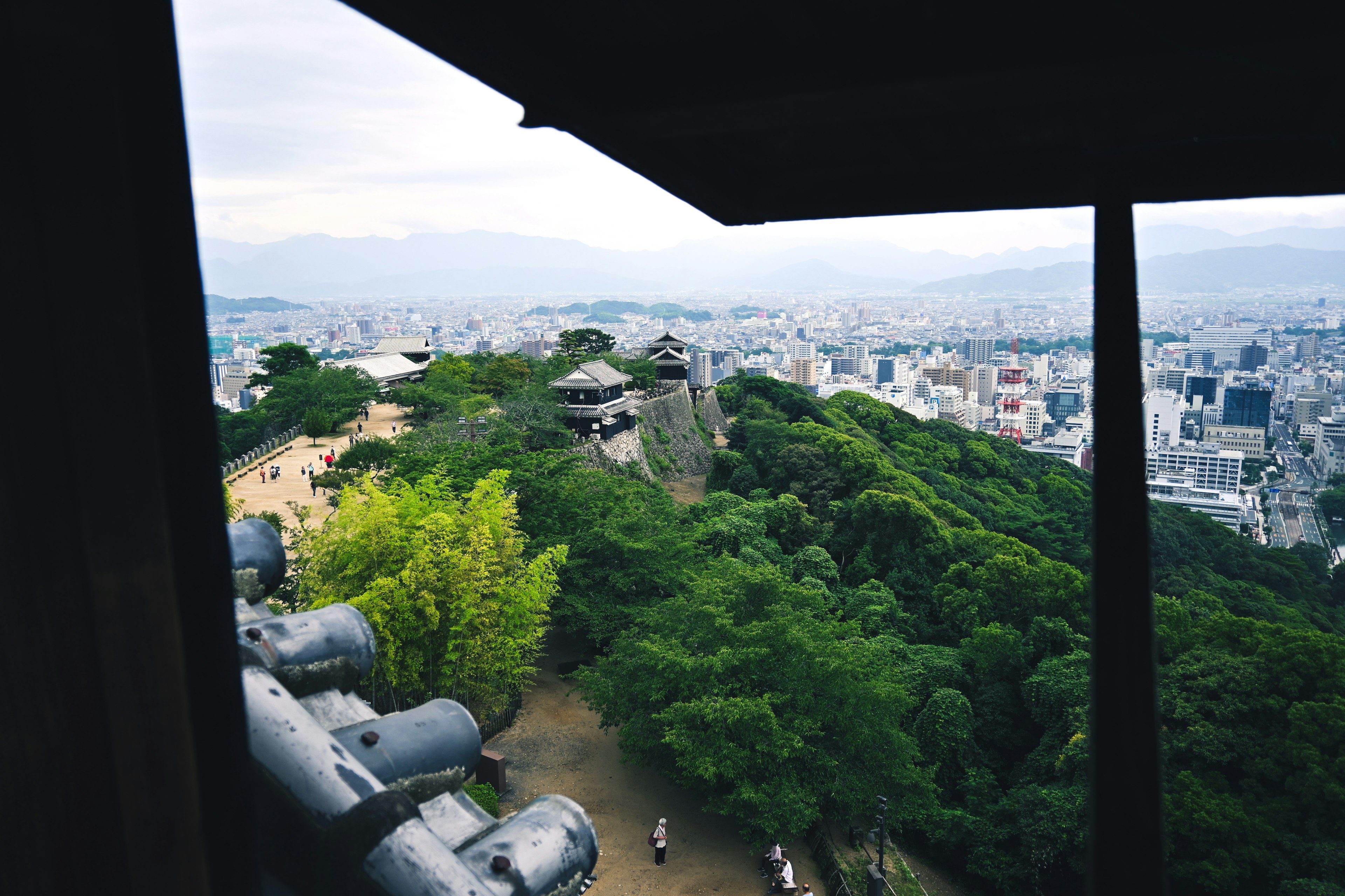 View from a high vantage point overlooking a cityscape and lush green hills