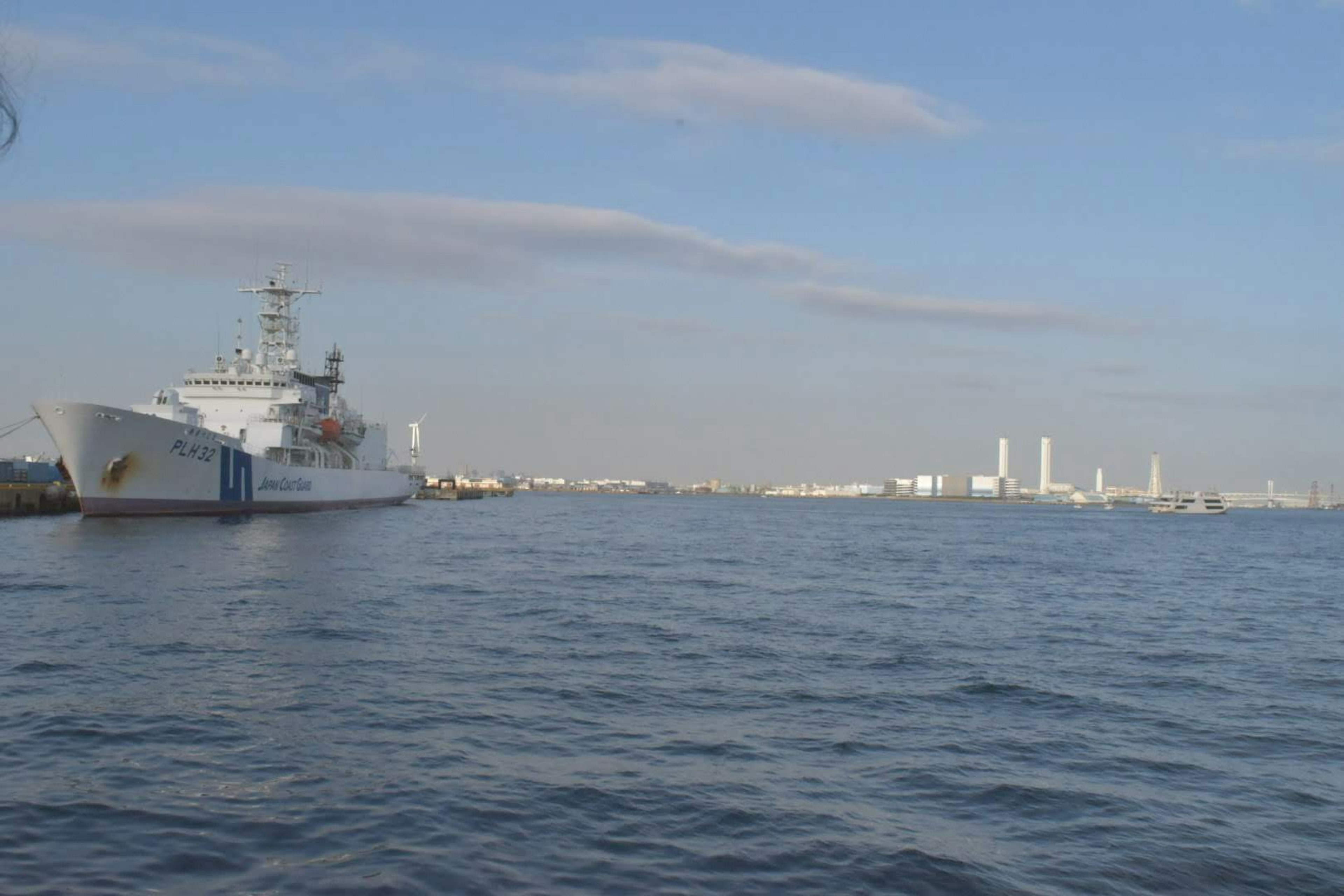 A ship on the water with a distant city skyline