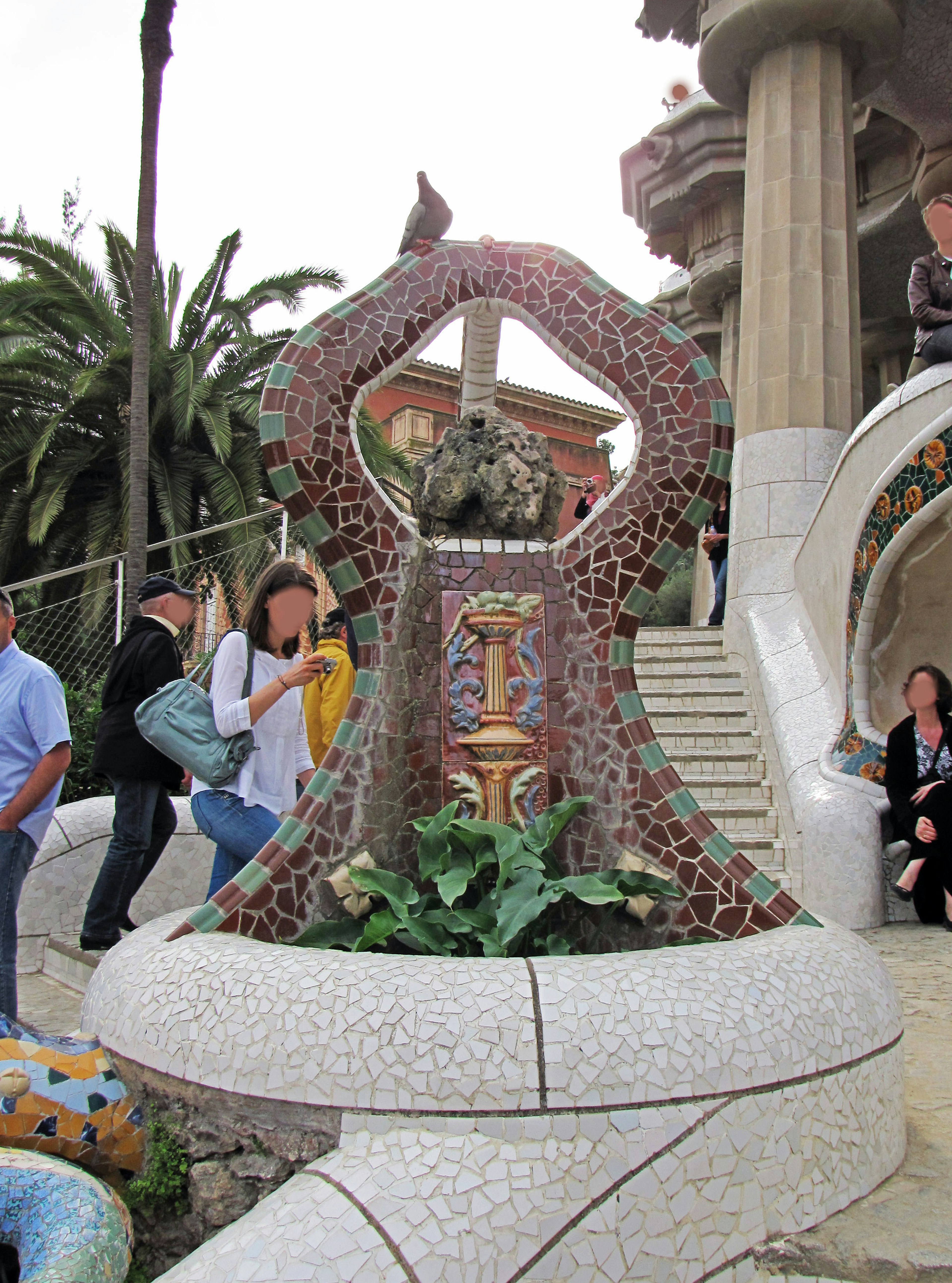 Fontana con decorazioni in mosaico e turisti al Parco Güell