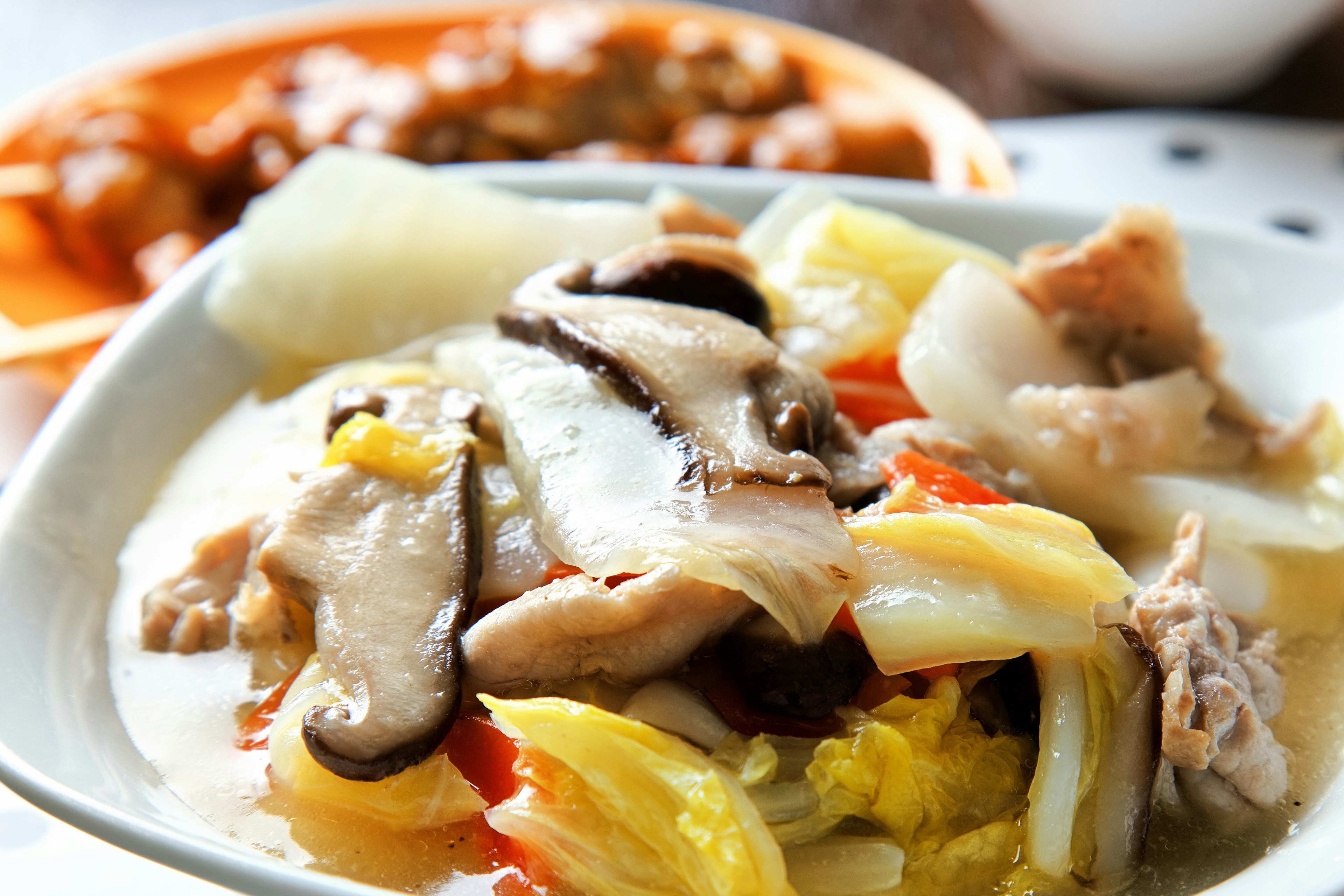 Colorful dish of vegetables and chicken served in a white bowl