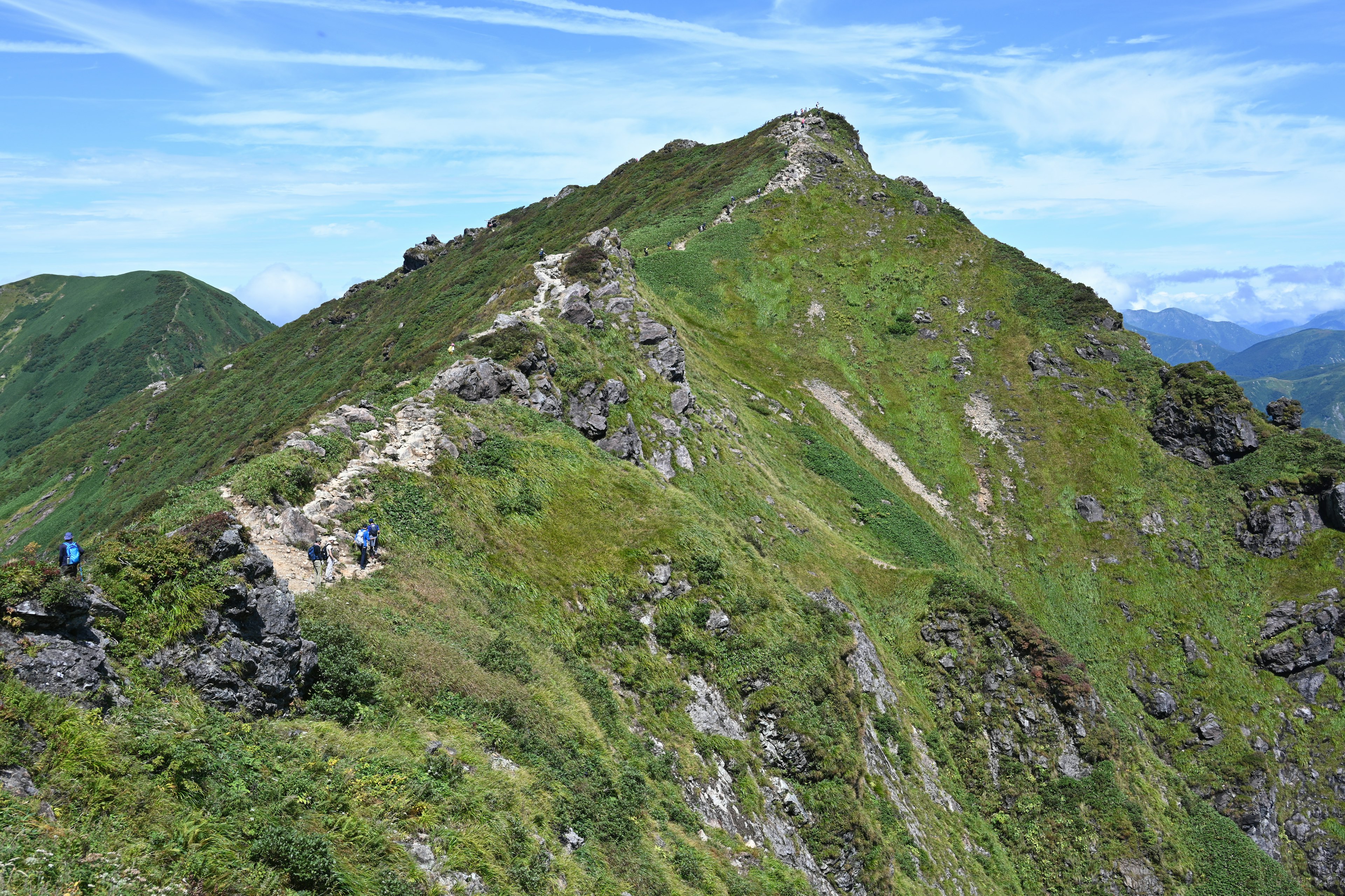 Scenic mountain ridge with hikers and lush greenery