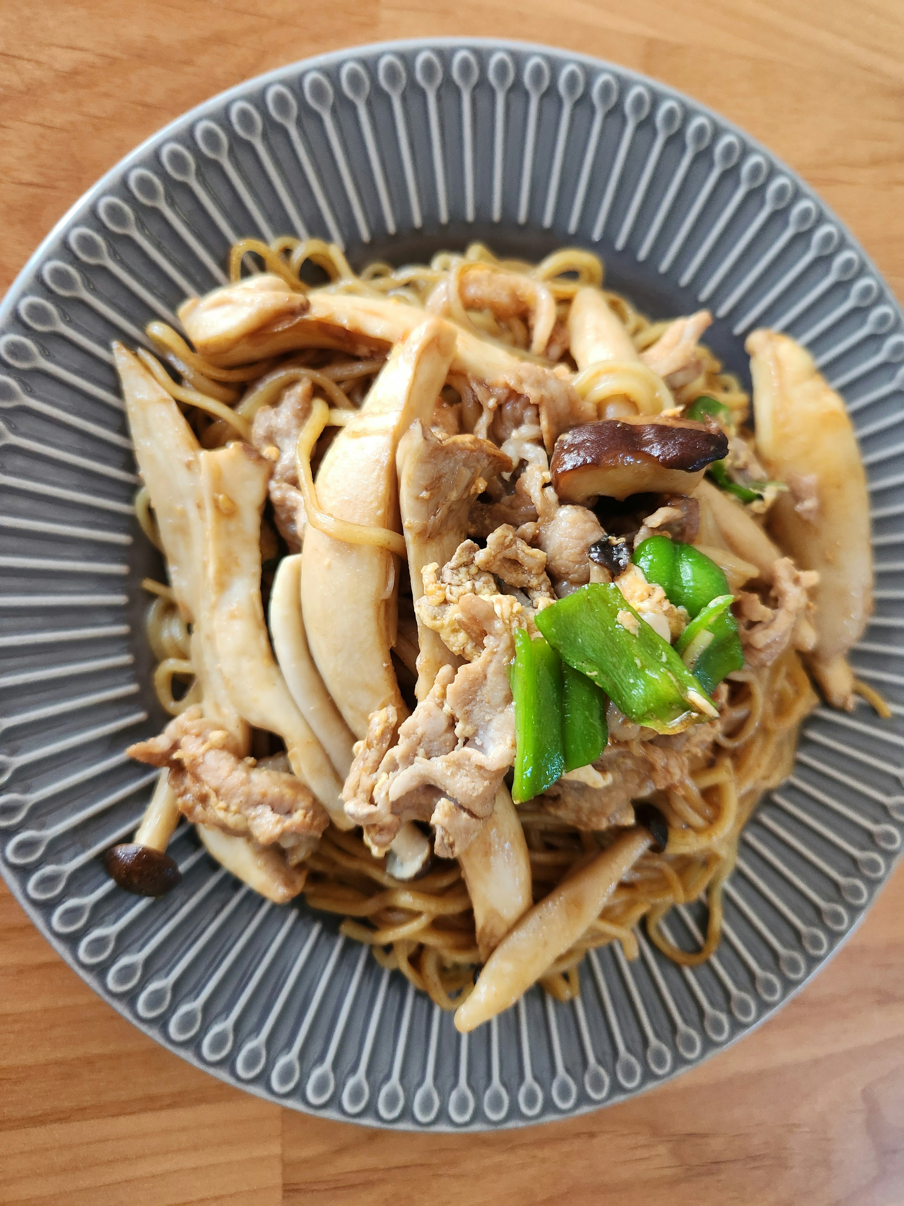 Fideos salteados con carne y verduras en un plato decorativo