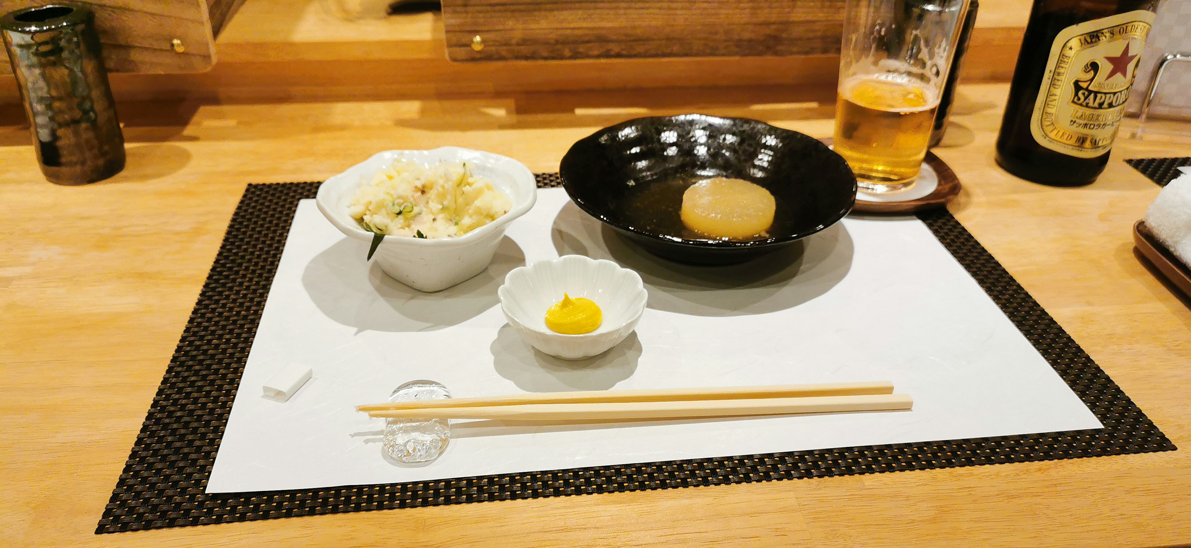 Mise en place avec un bol noir contenant un œuf et un petit plat blanc avec un jaune d'œuf