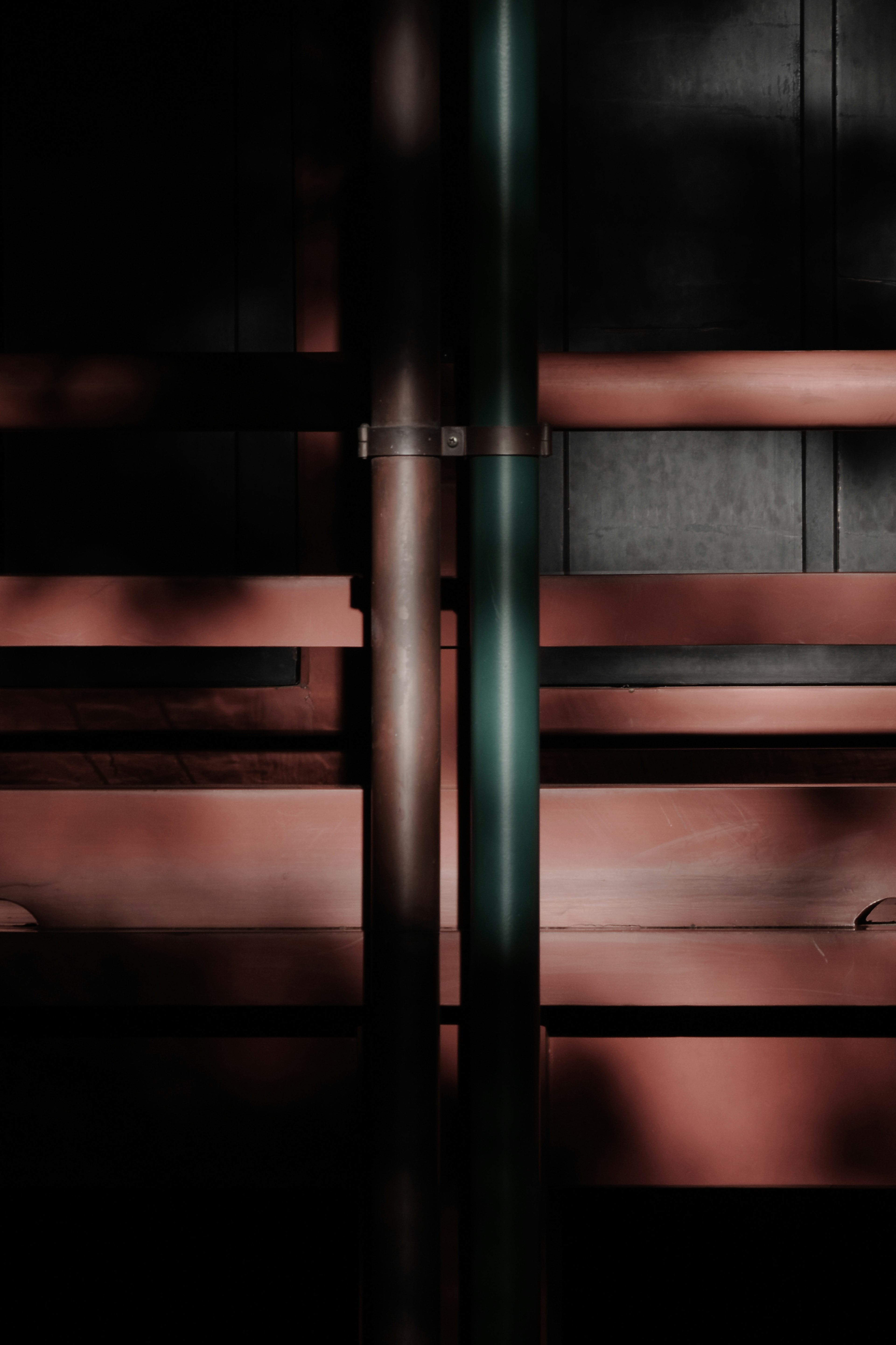 Abstract composition with metallic pipes intersecting against a dark background and wooden textures