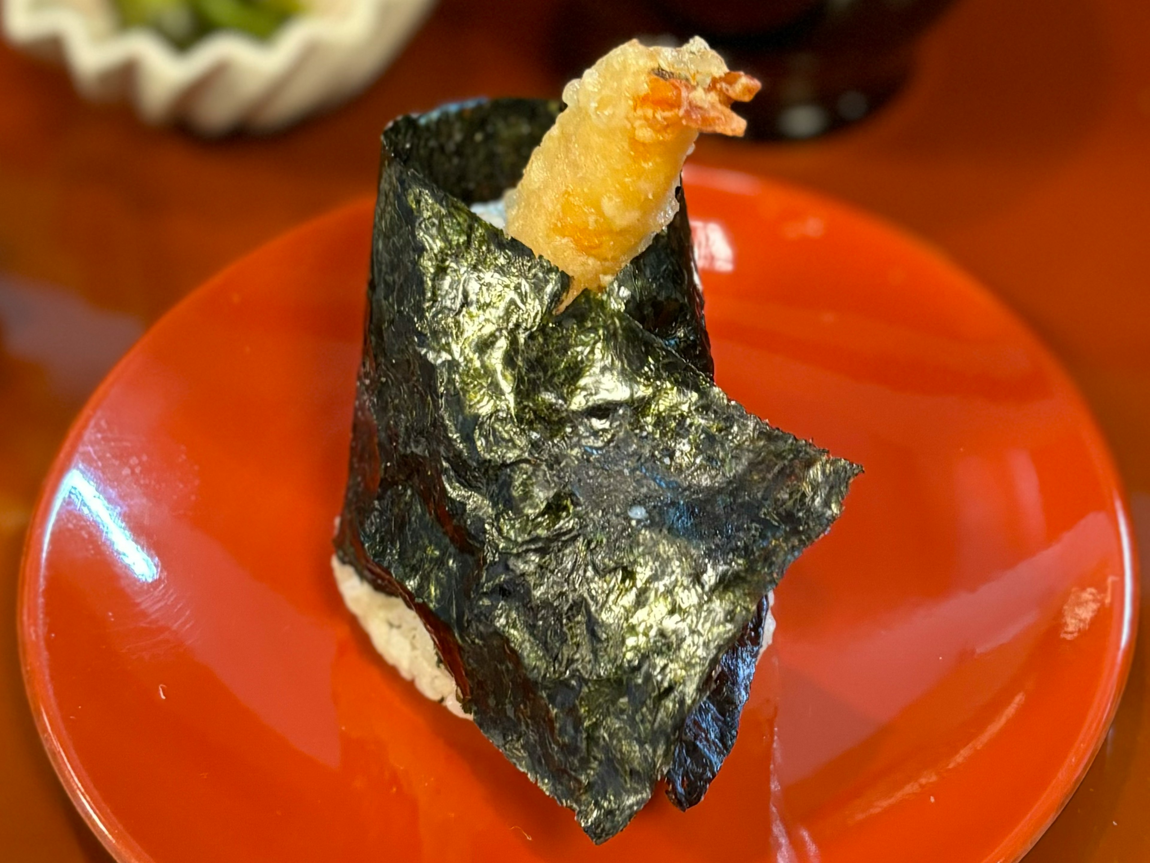 Sushi envuelto en algas con tempura de camarón encima