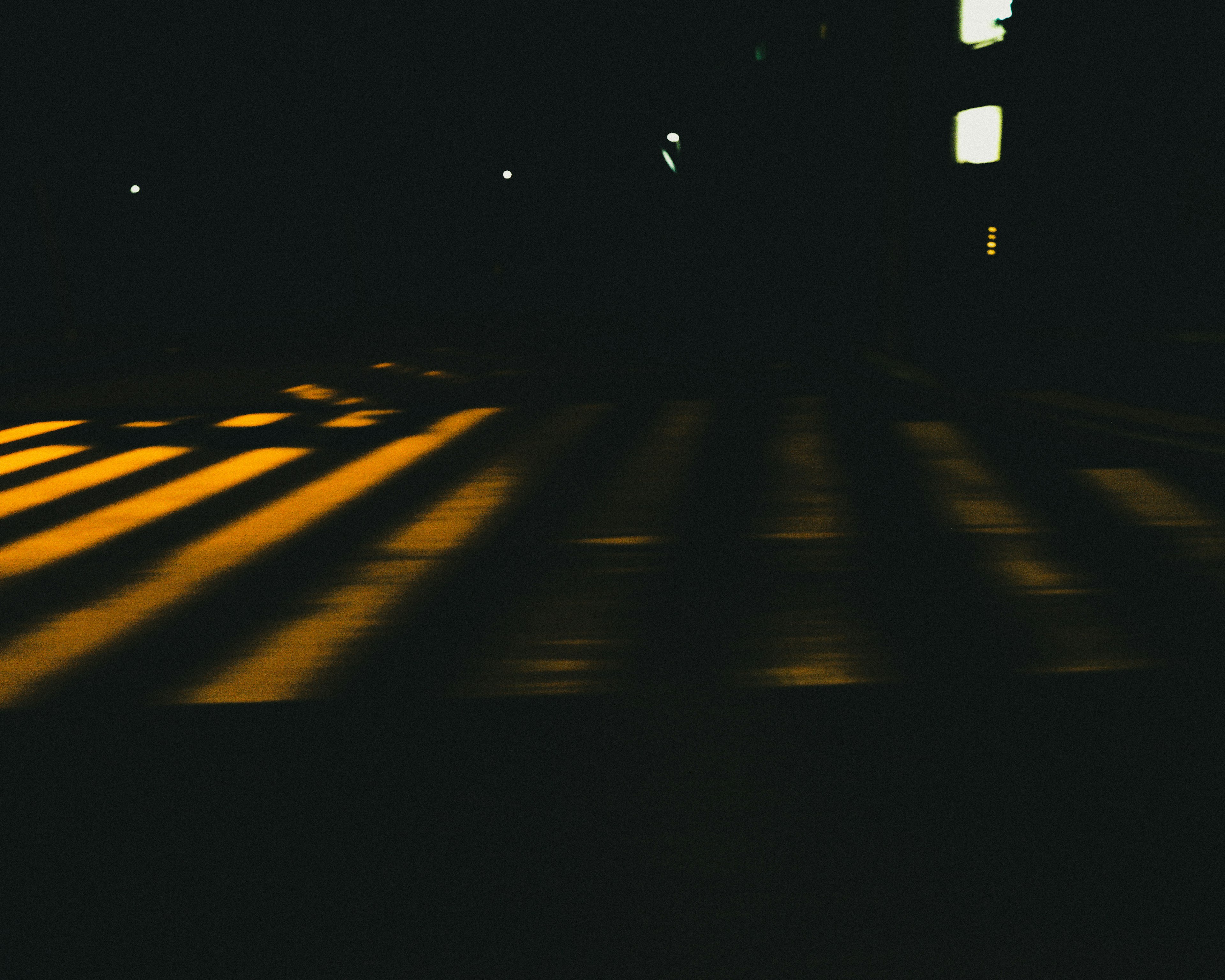 Yellow crosswalk stripes illuminated at night