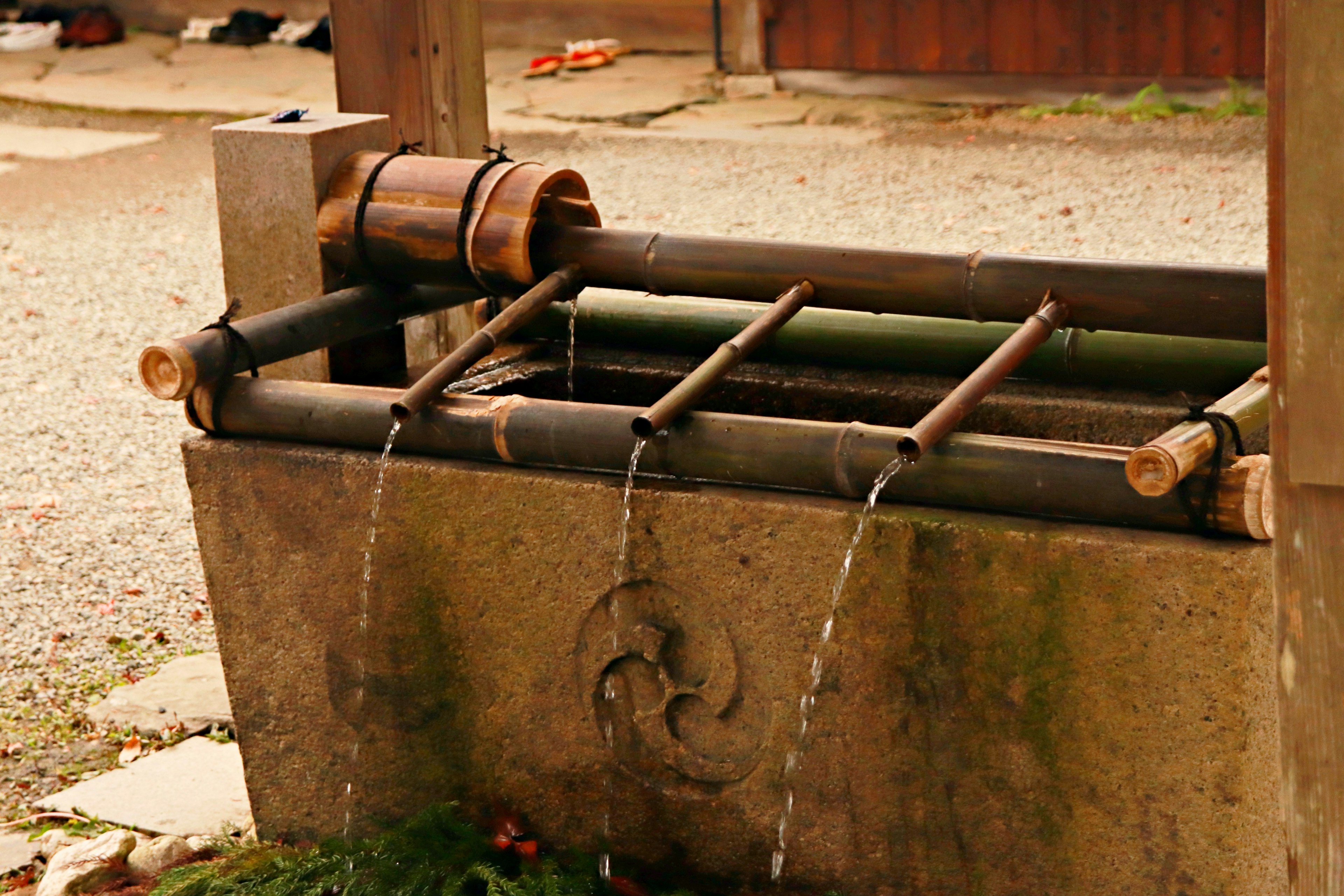 Structure de puits traditionnel avec de l'eau qui coule en bambou