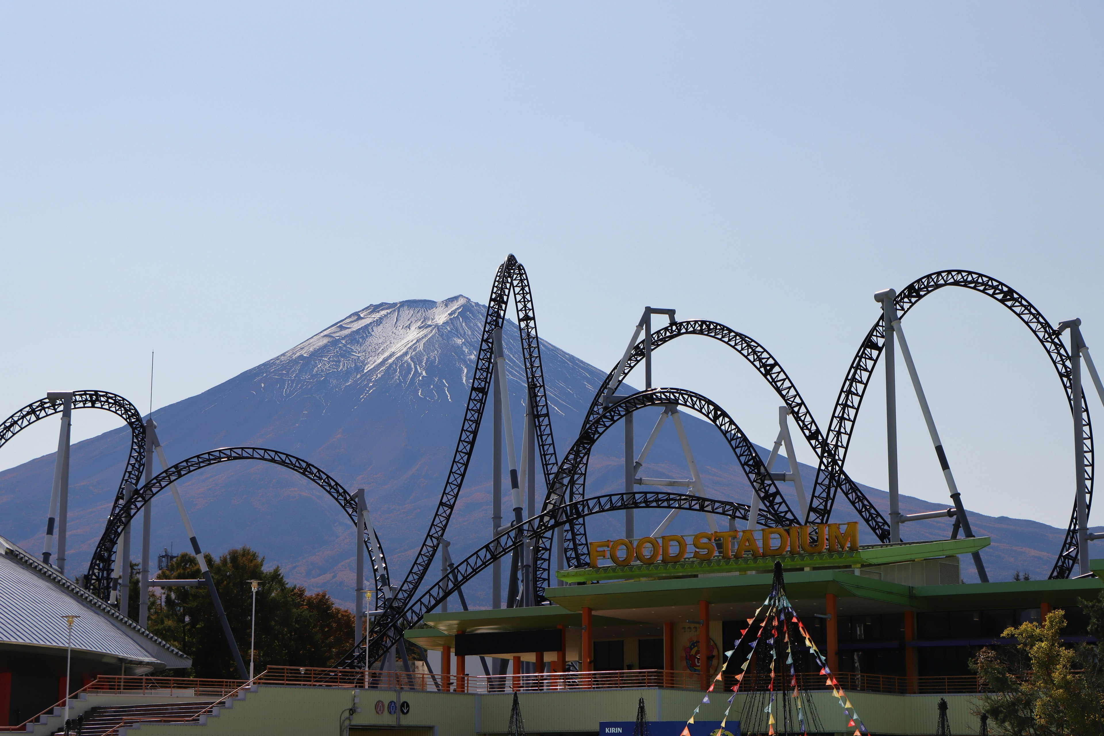 Atraksi roller coaster dengan latar belakang Gunung Fuji