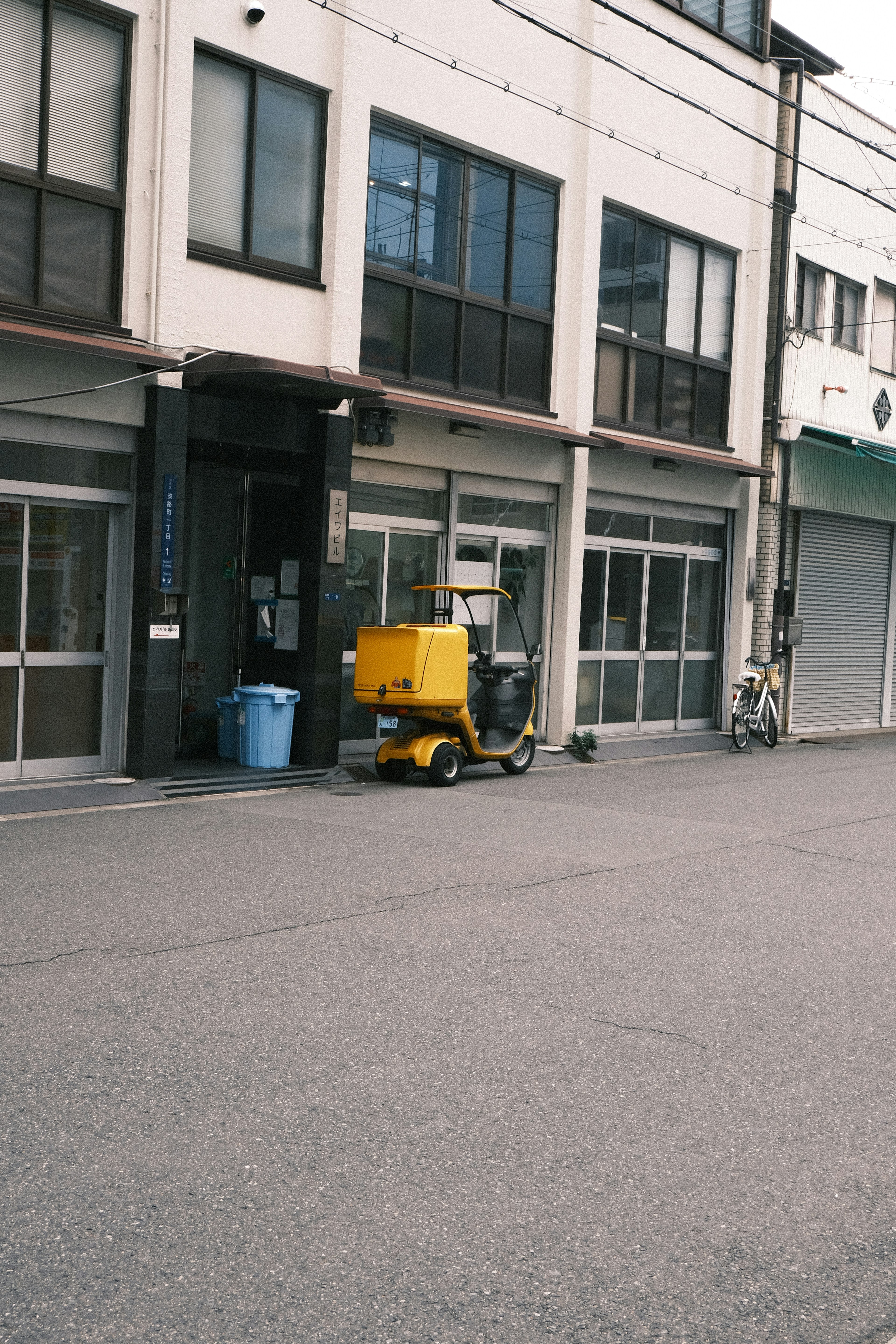 黄色の機械が道路に置かれた静かな街並み