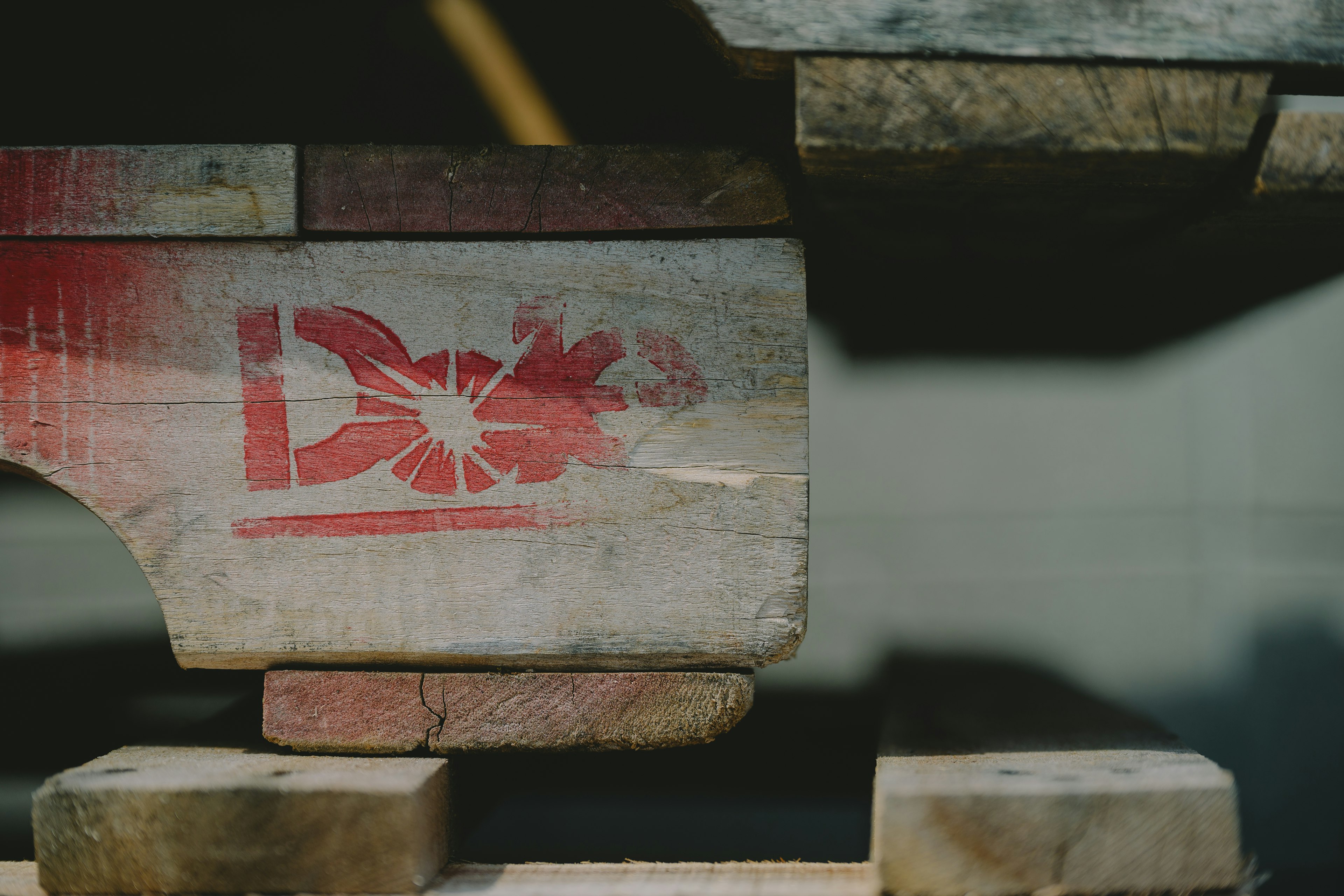 Side view of a wooden pallet featuring a red logo