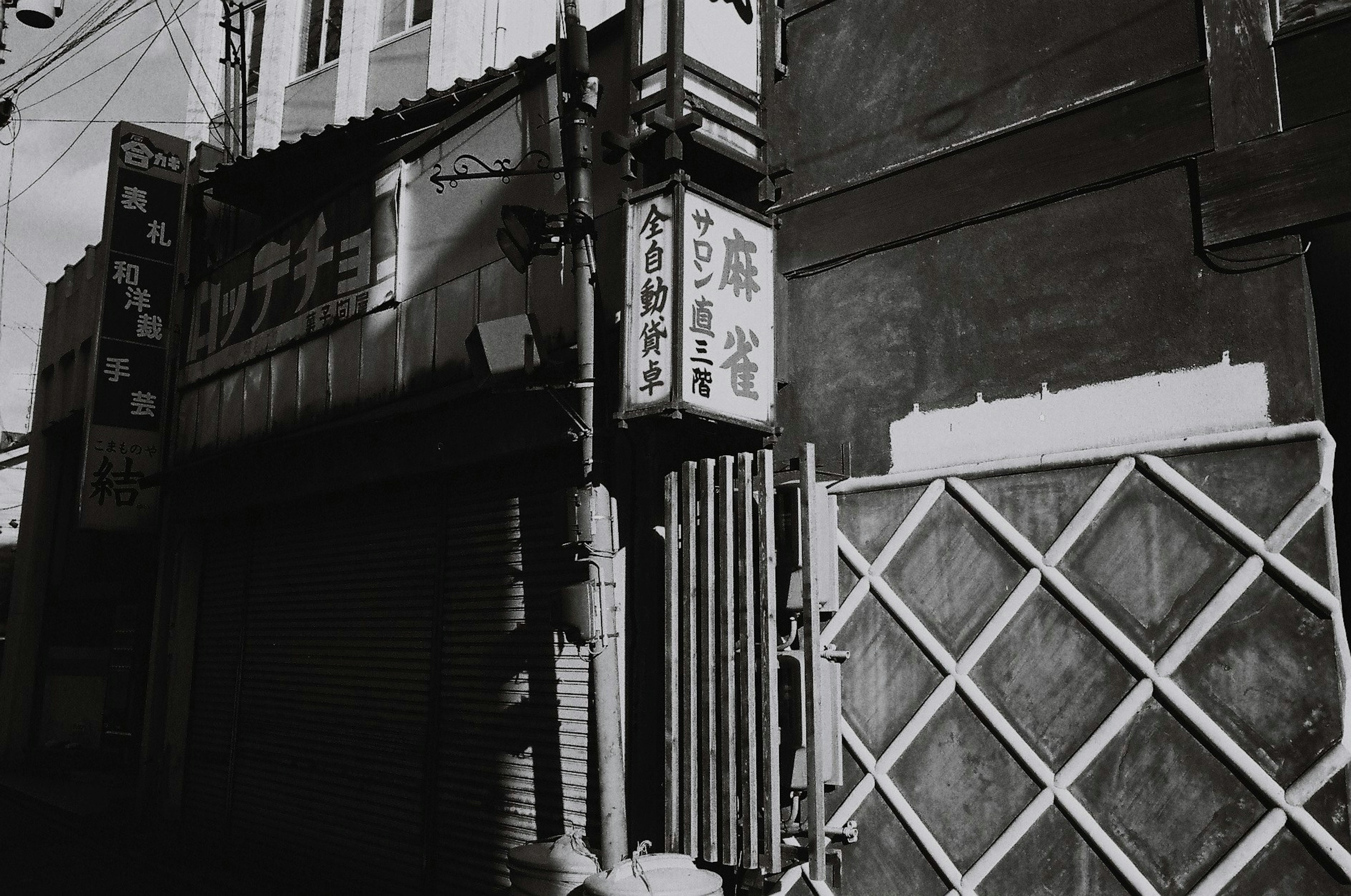 A narrow alley featuring an old sign and a closed shuttered building