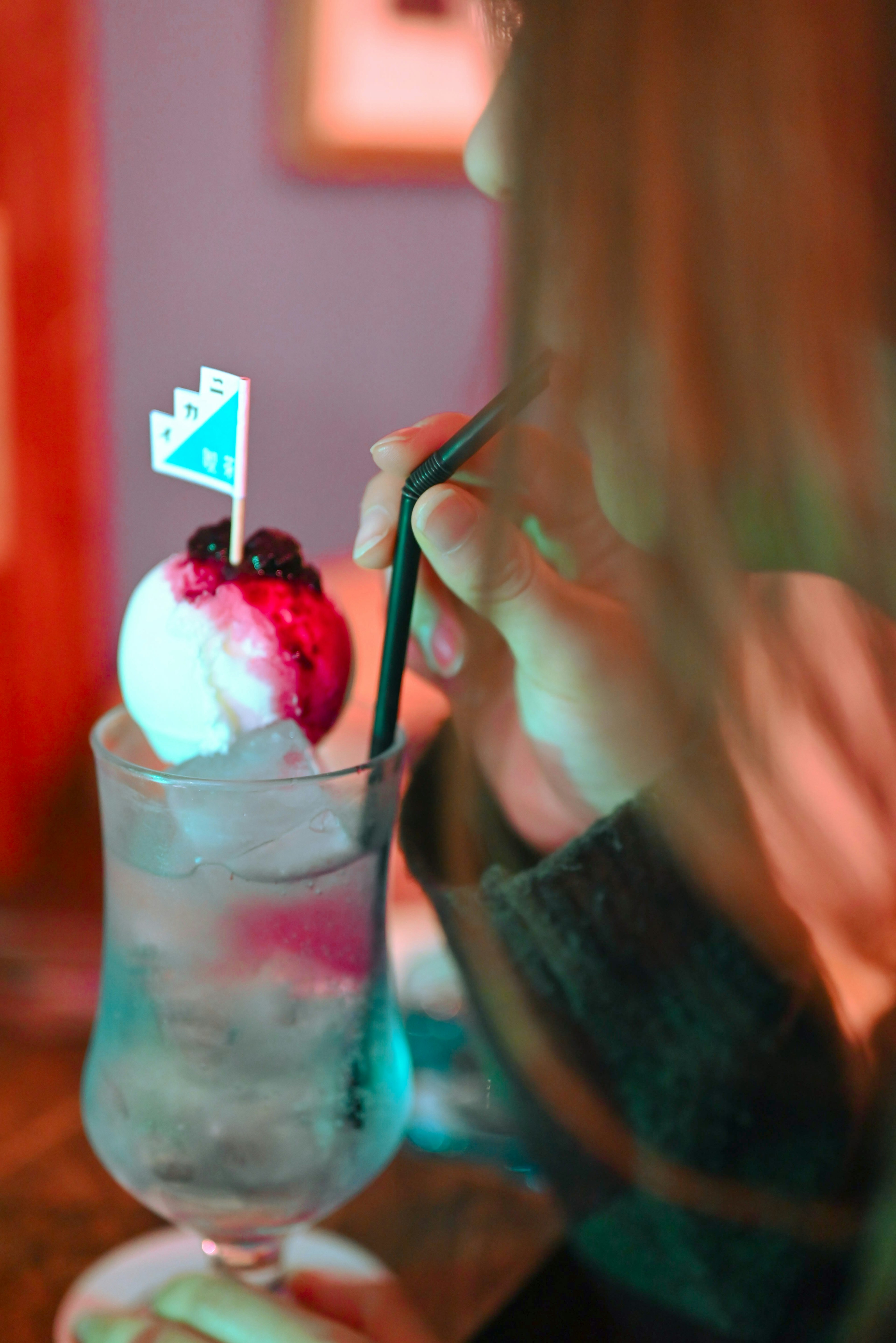 Gros plan sur un cocktail avec de la glace dégusté par une femme