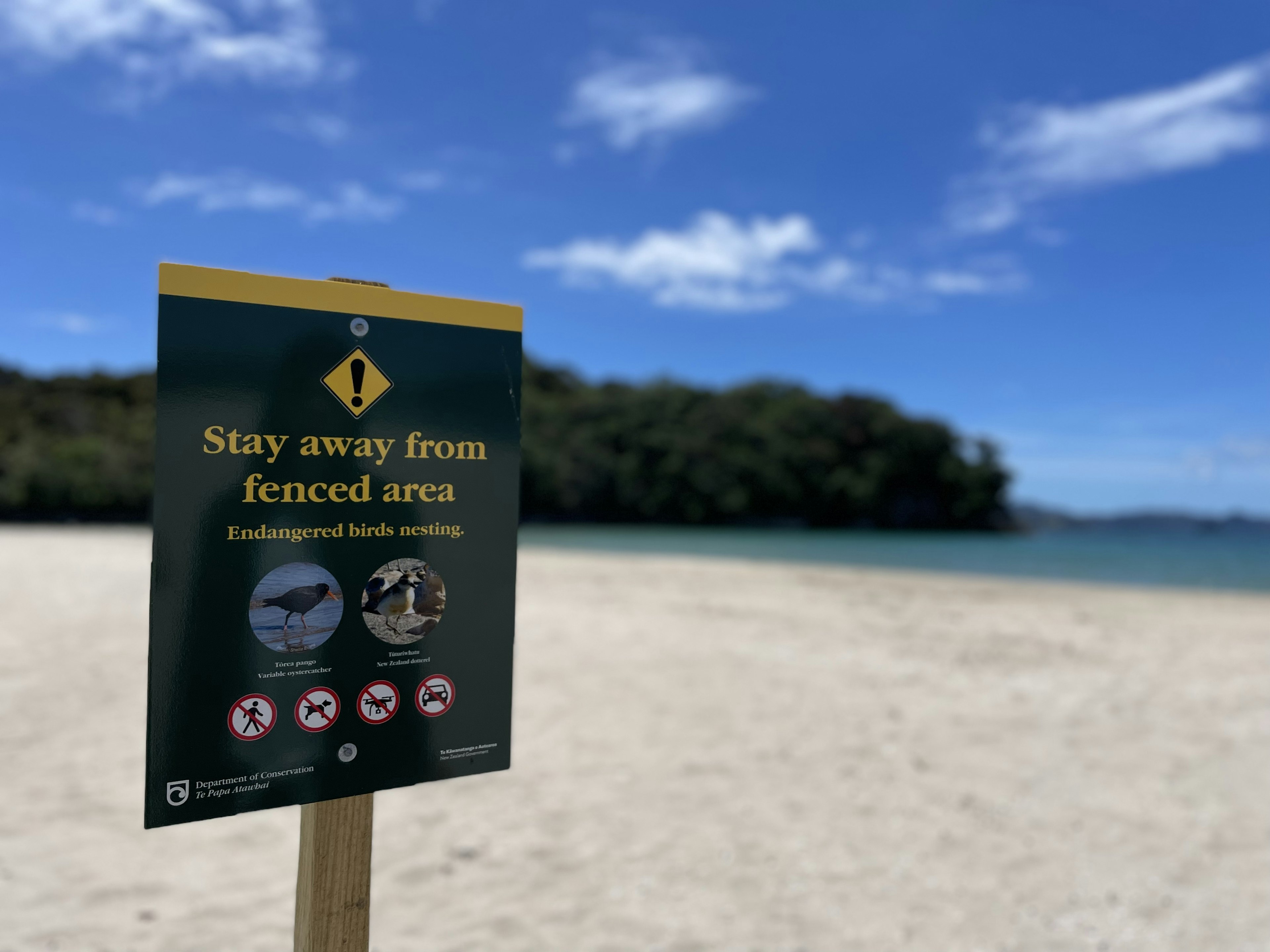 Sign instructing to stay away from fenced area on a beach