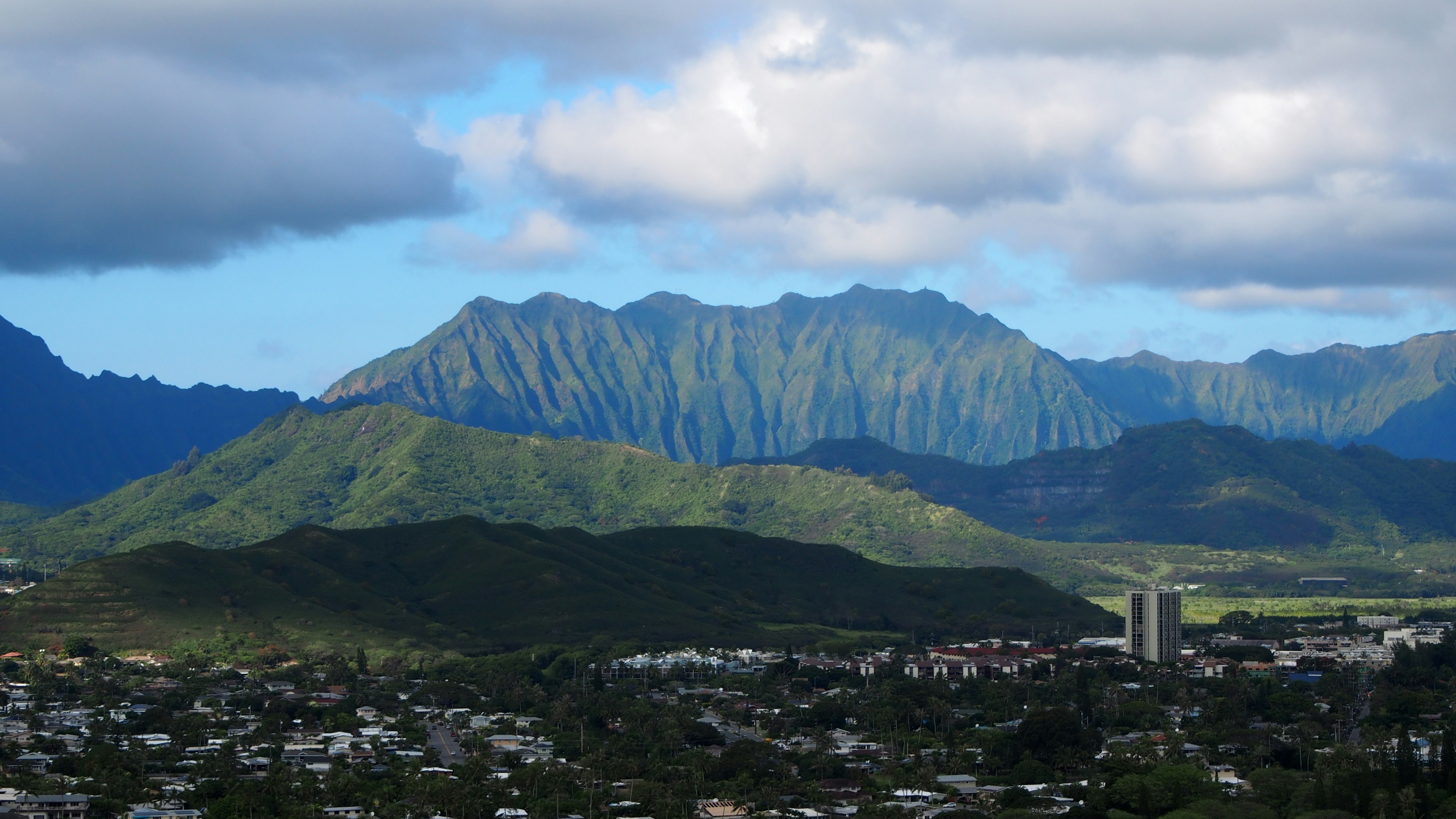 Vue panoramique de montagnes verdoyantes et d'une ville sous un ciel bleu