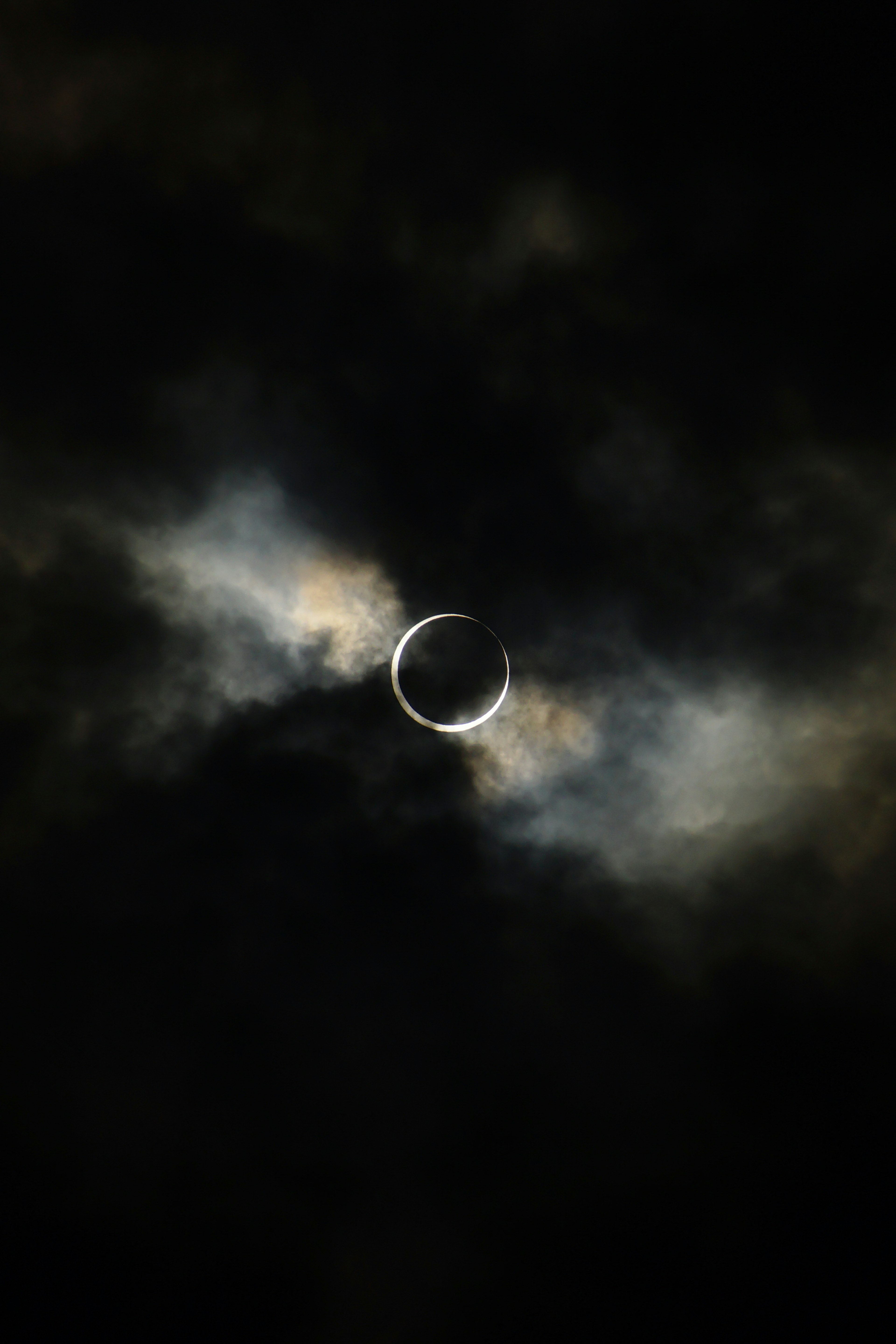 Ring-shaped celestial body surrounded by dark clouds