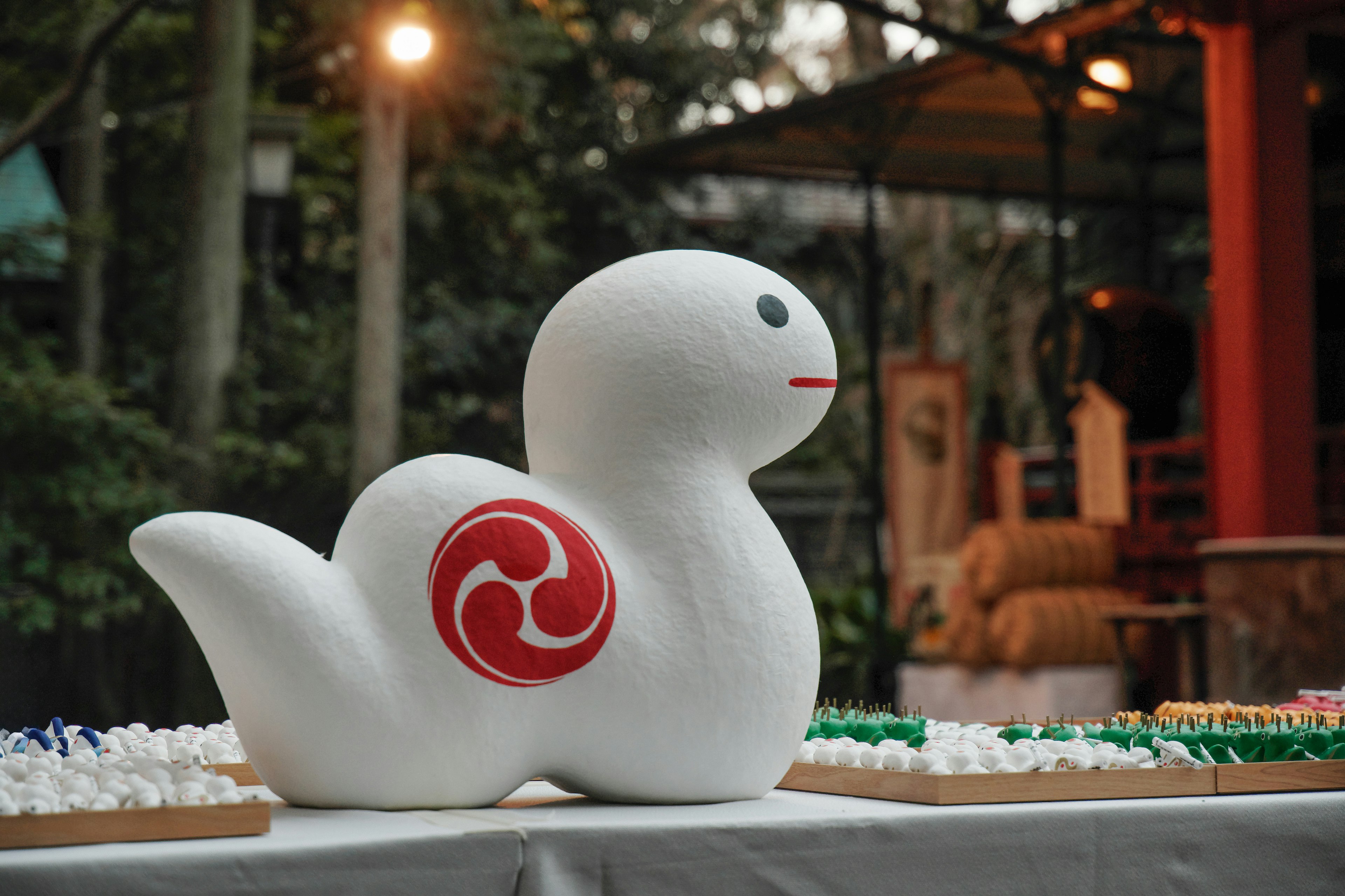 White sculpture resembling a mythical creature with a red swirl design