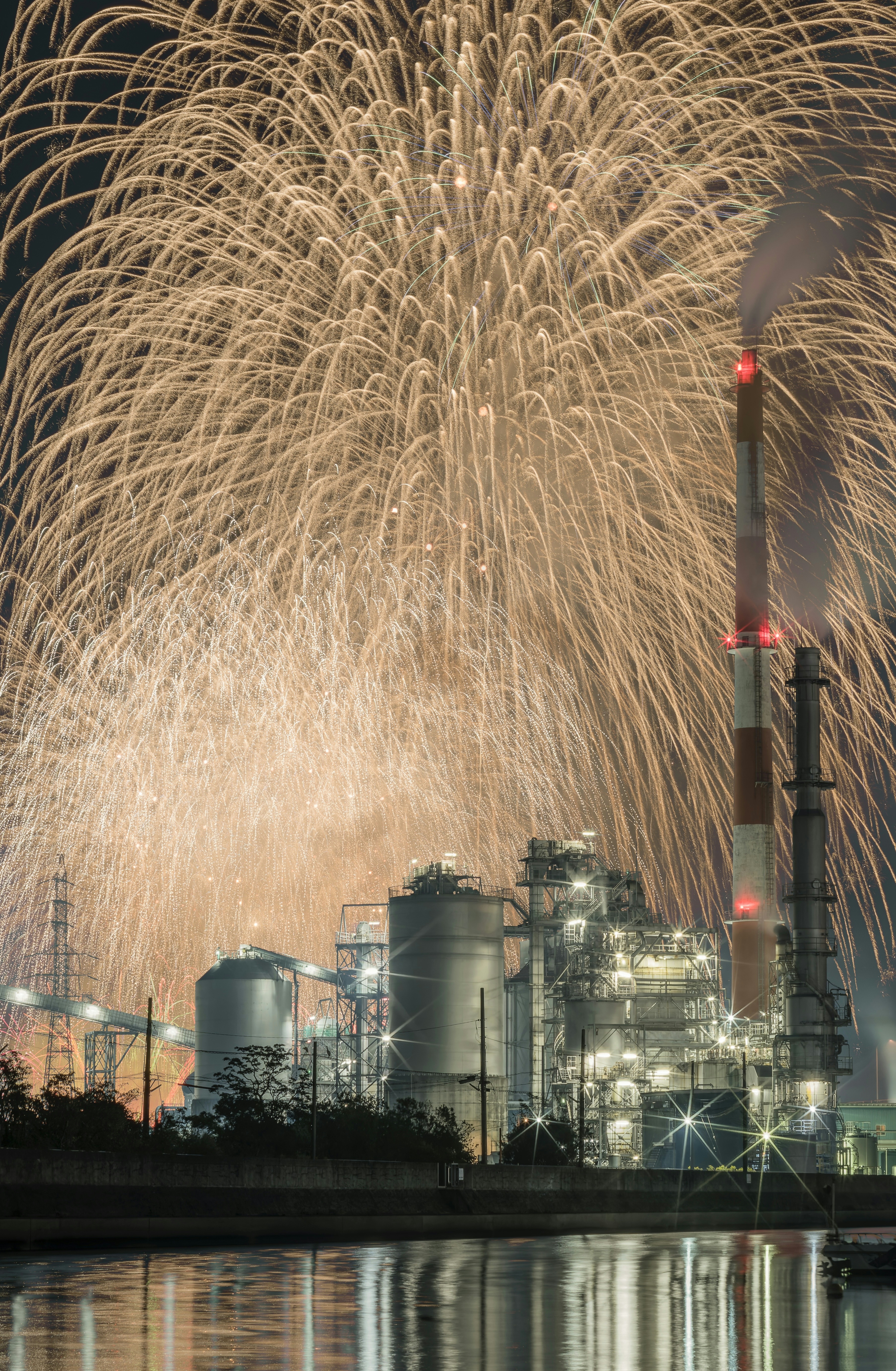 工場の夜景と花火の美しいコントラスト