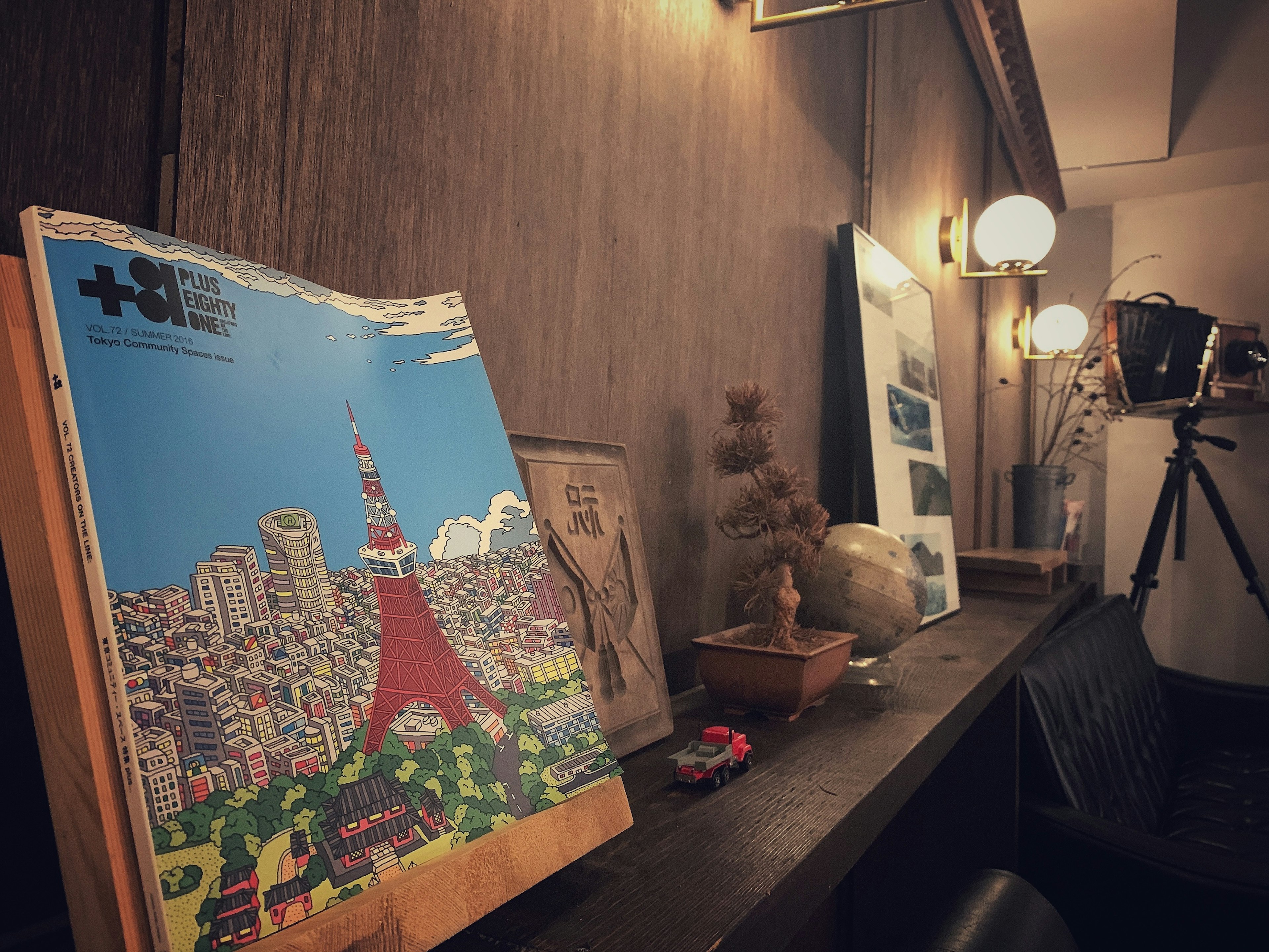 A book featuring an illustration of Tokyo Tower with decorative items and a camera nearby