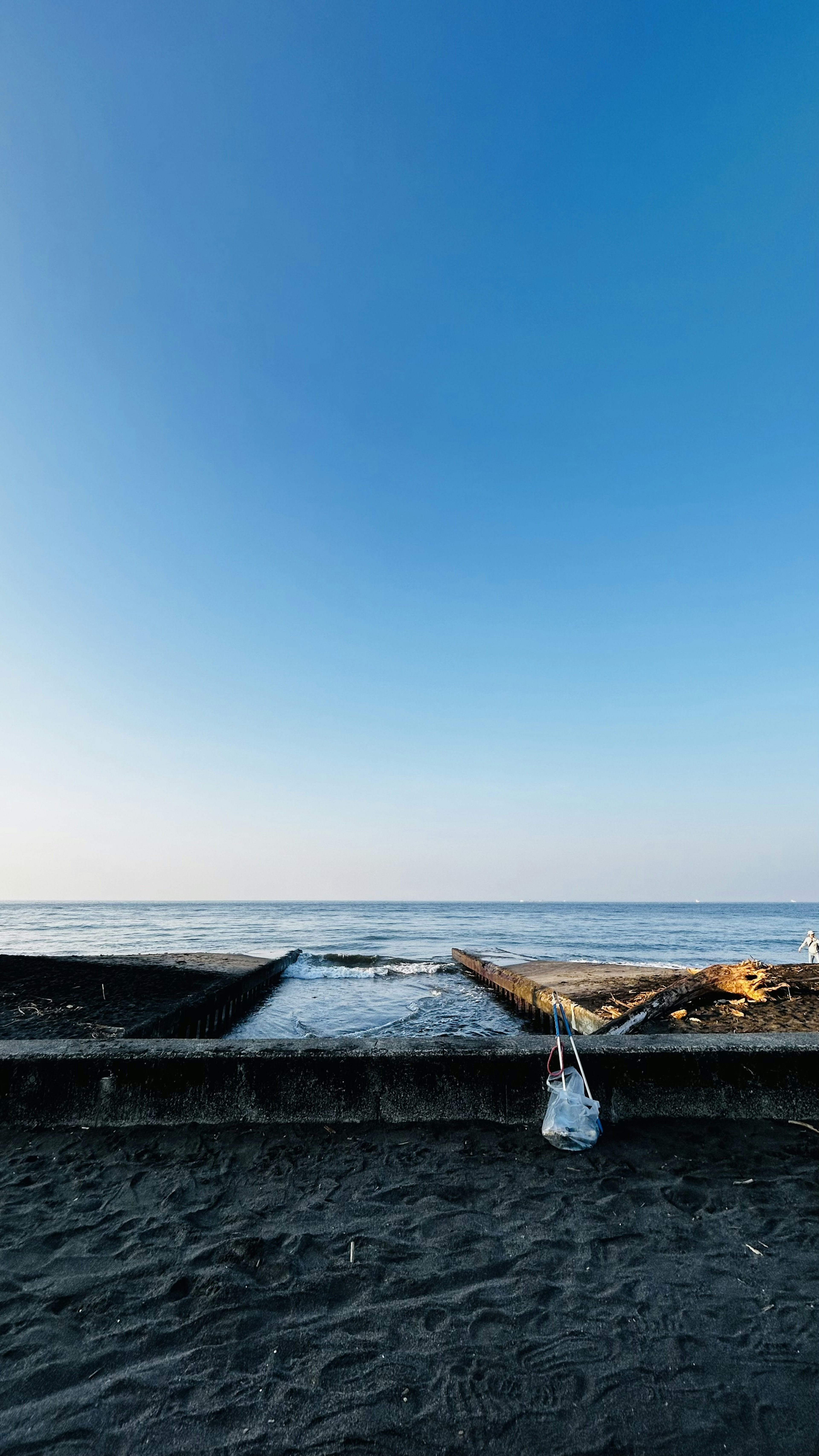 Scène de plage avec ciel bleu clair et océan Bois flotté et bateau sur le rivage