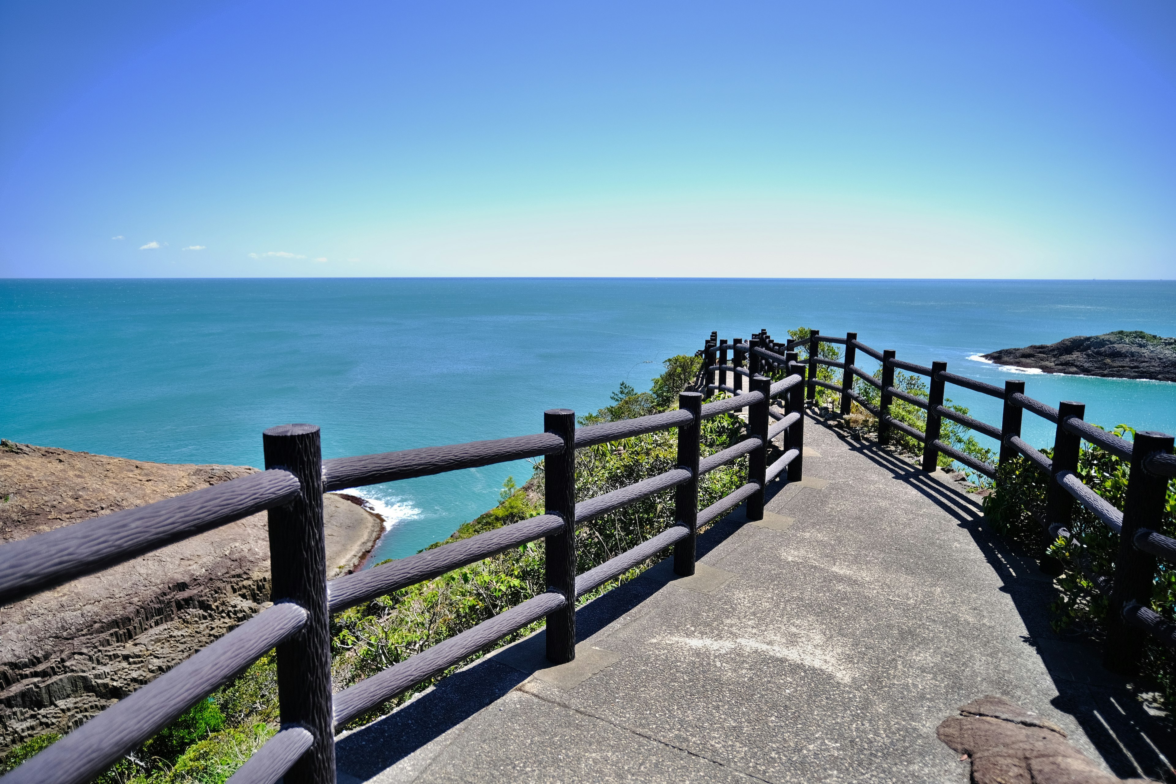 Coastal walkway with a clear blue sea and sky