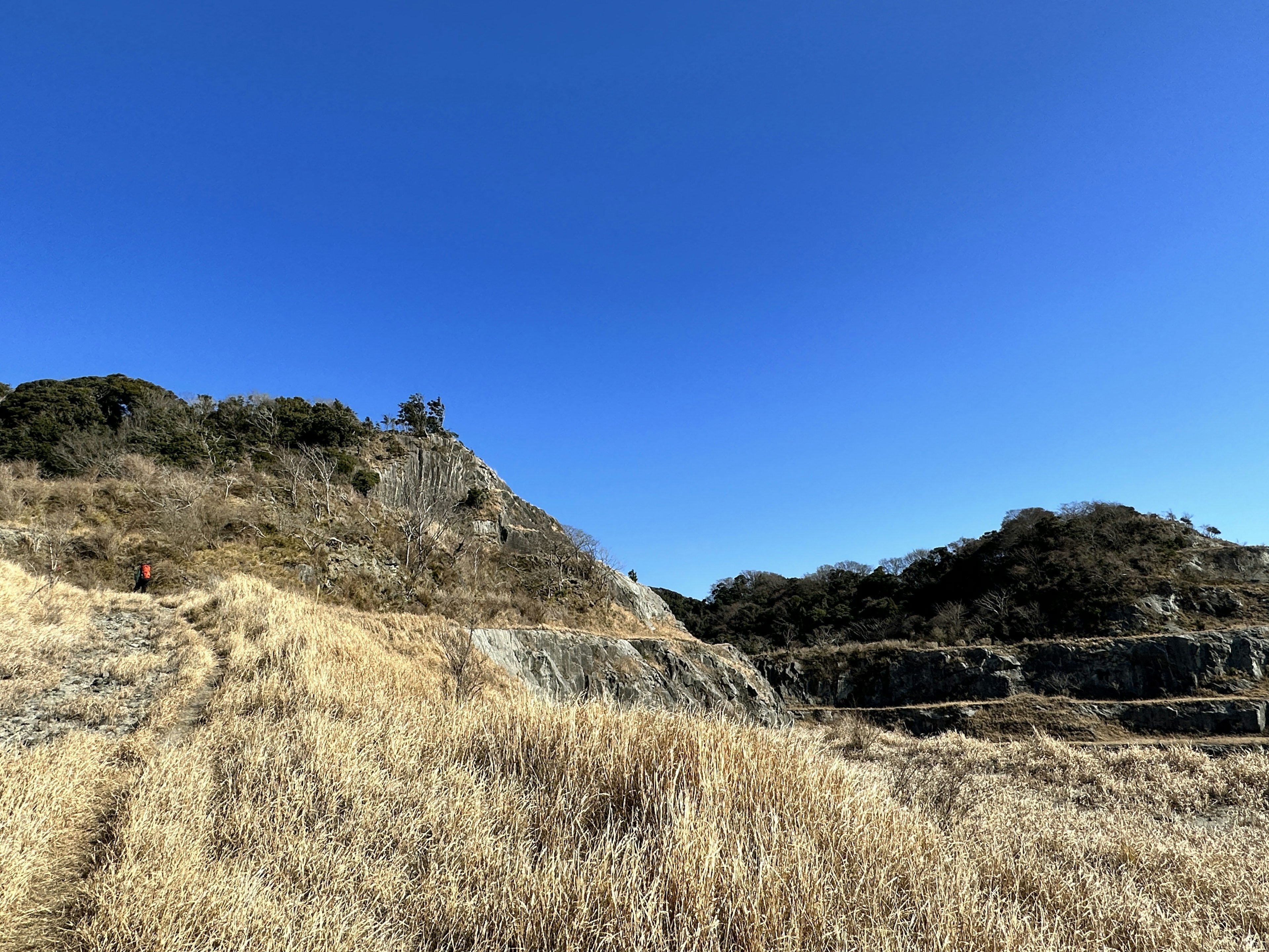 Landschaft mit Gras und Felsen unter blauem Himmel