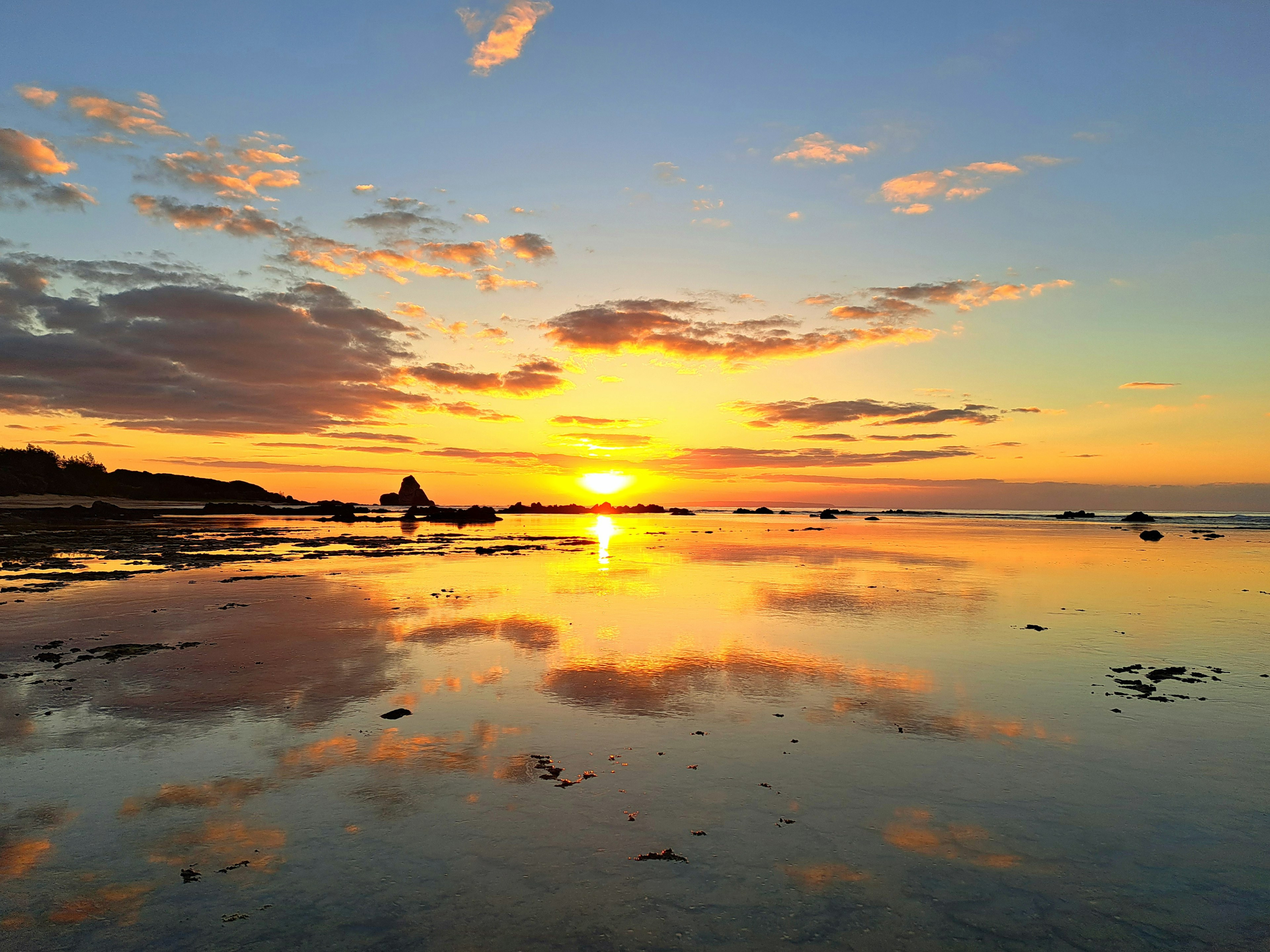 Scenic sunset reflecting on the ocean with a silhouette of a person