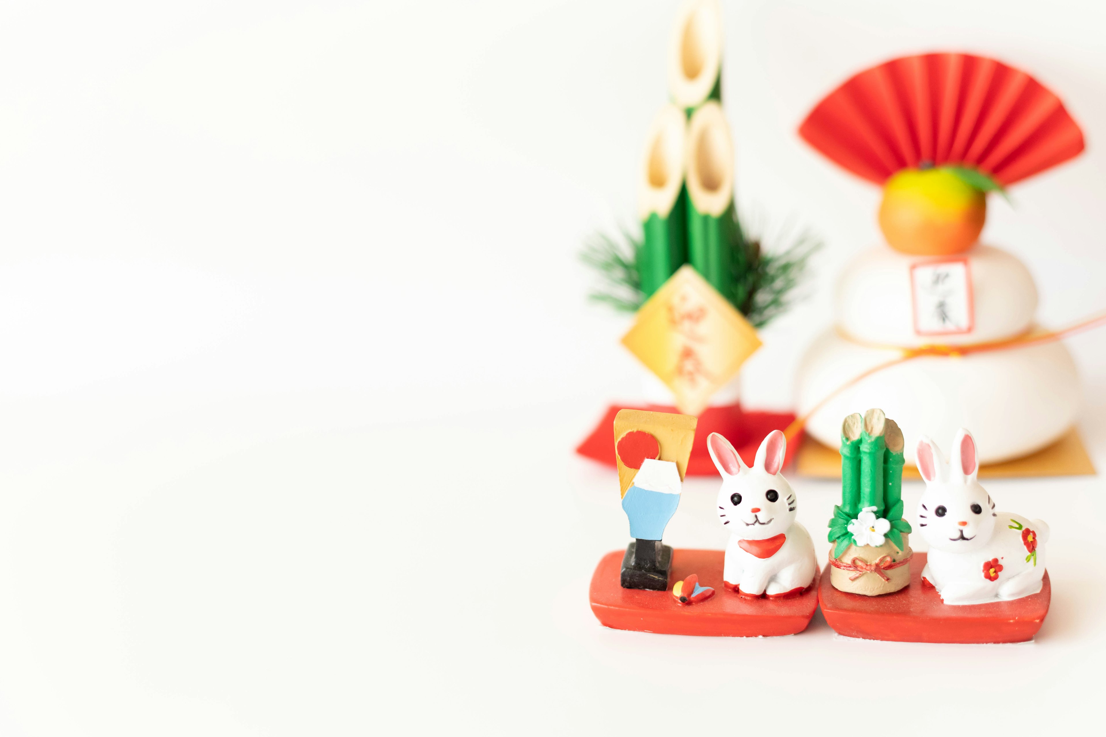 Carinissime figurine di coniglietti con decorazioni di Capodanno su sfondo bianco