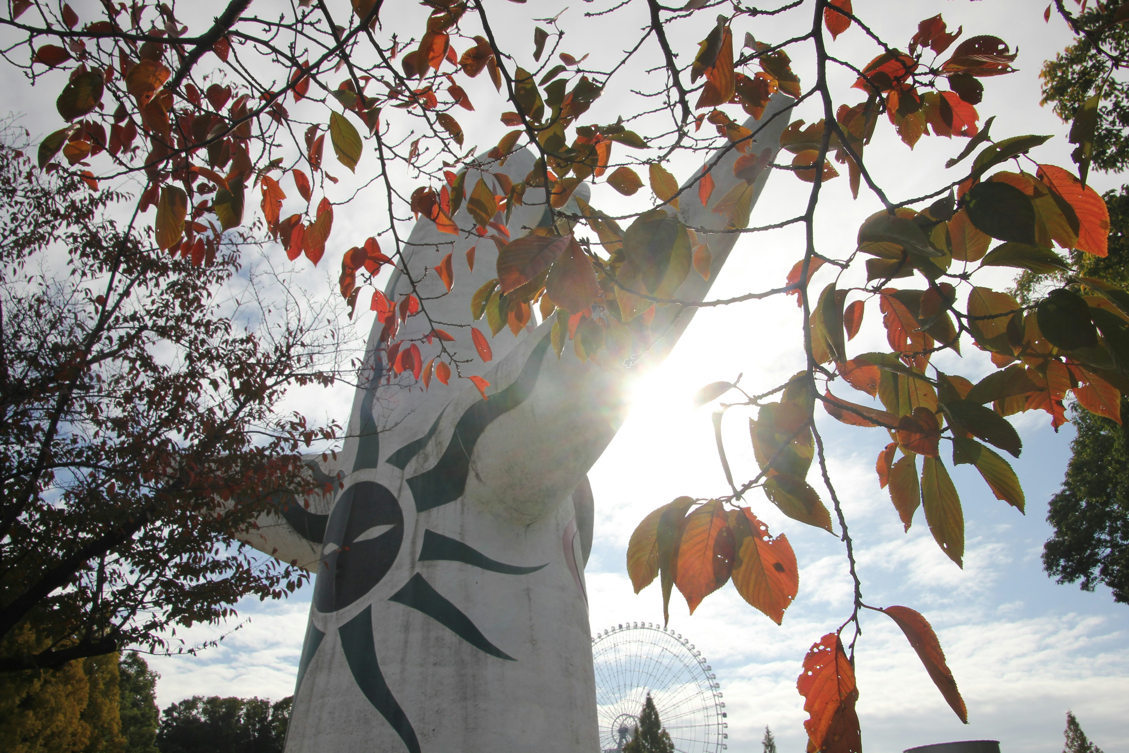 Sculpture surrounded by autumn leaves illuminated by sunlight