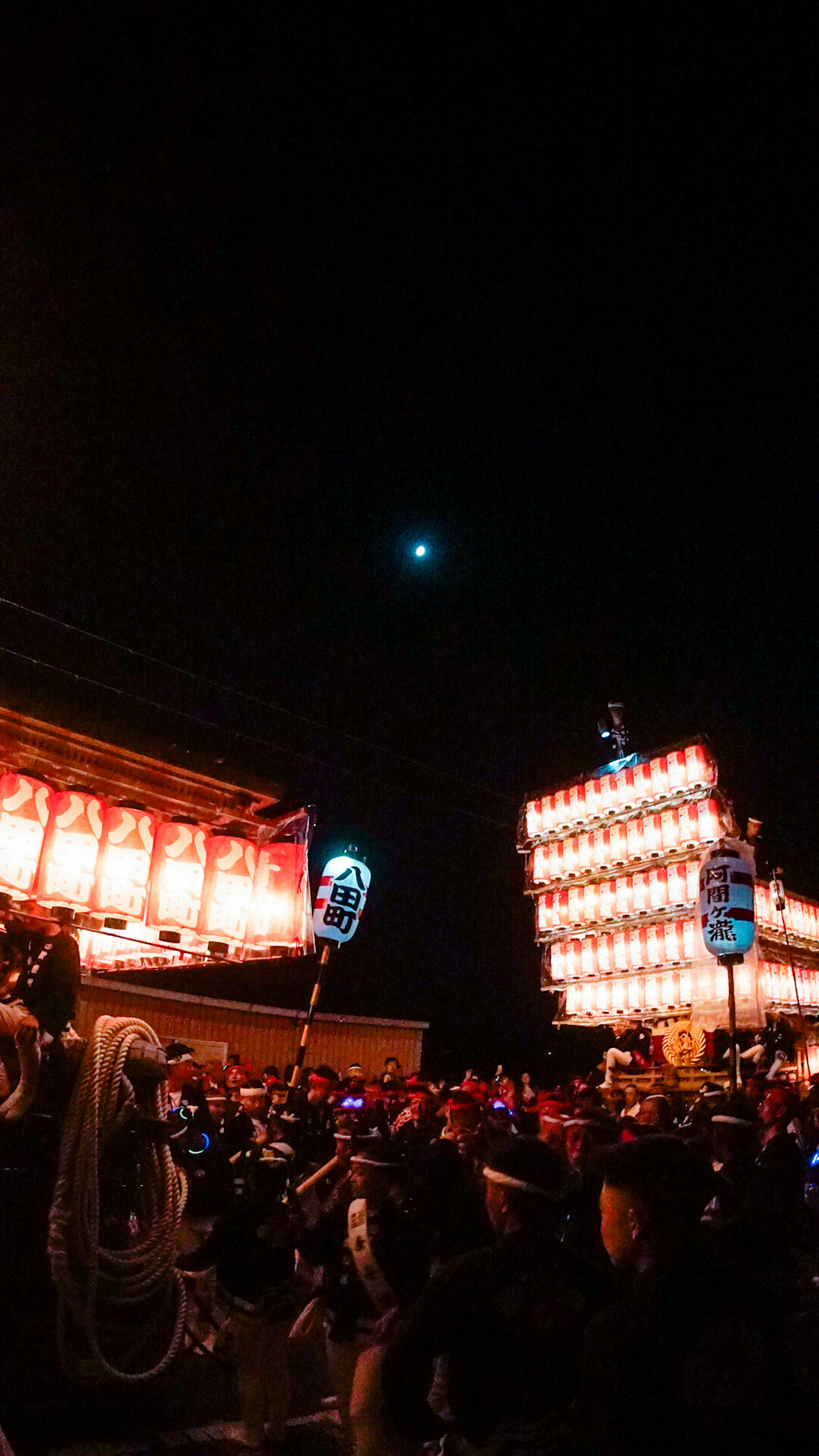 Scena di festival notturno con lanterne e folla di persone