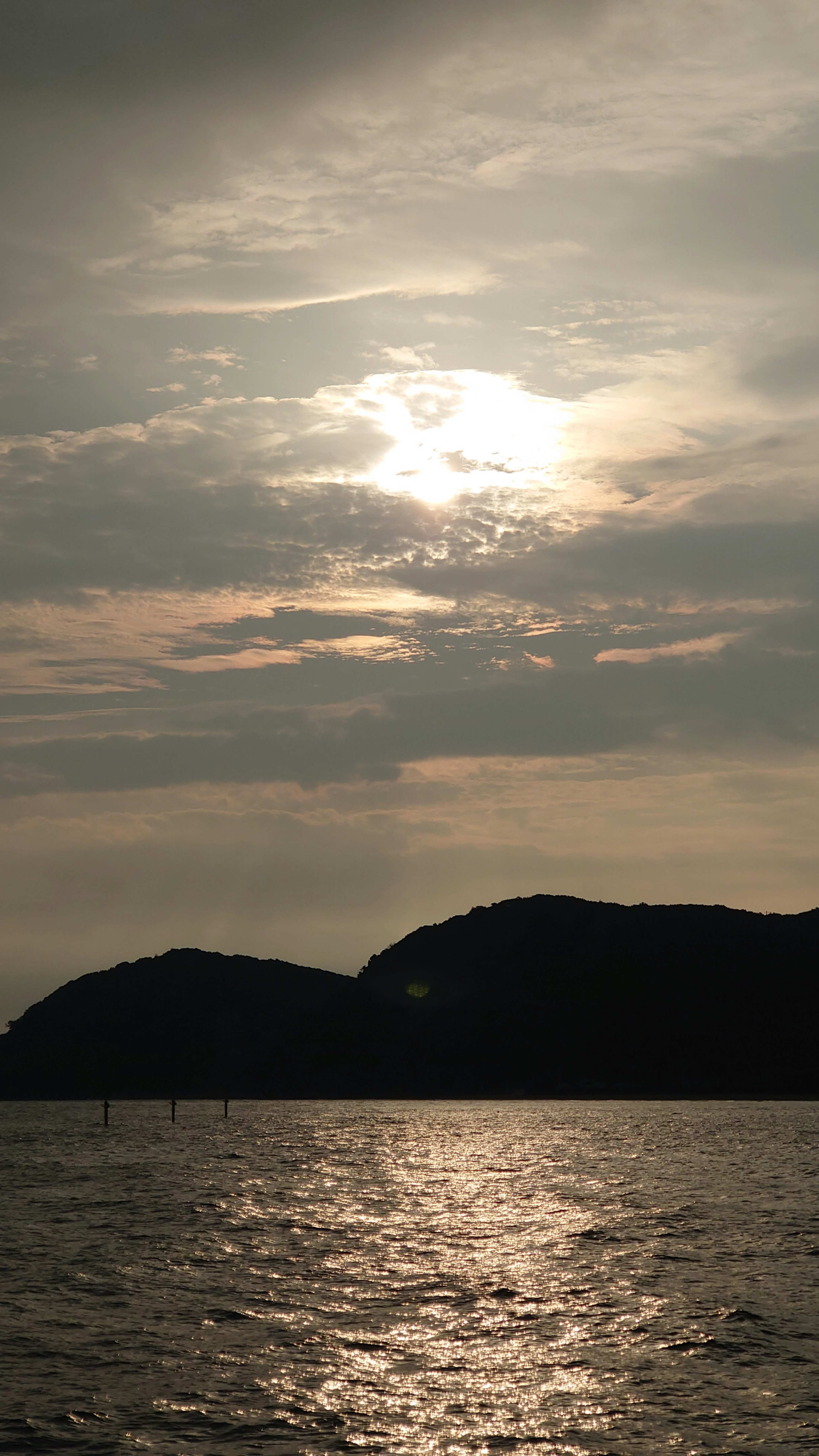 Luce del sole che si riflette sul mare con cielo nuvoloso