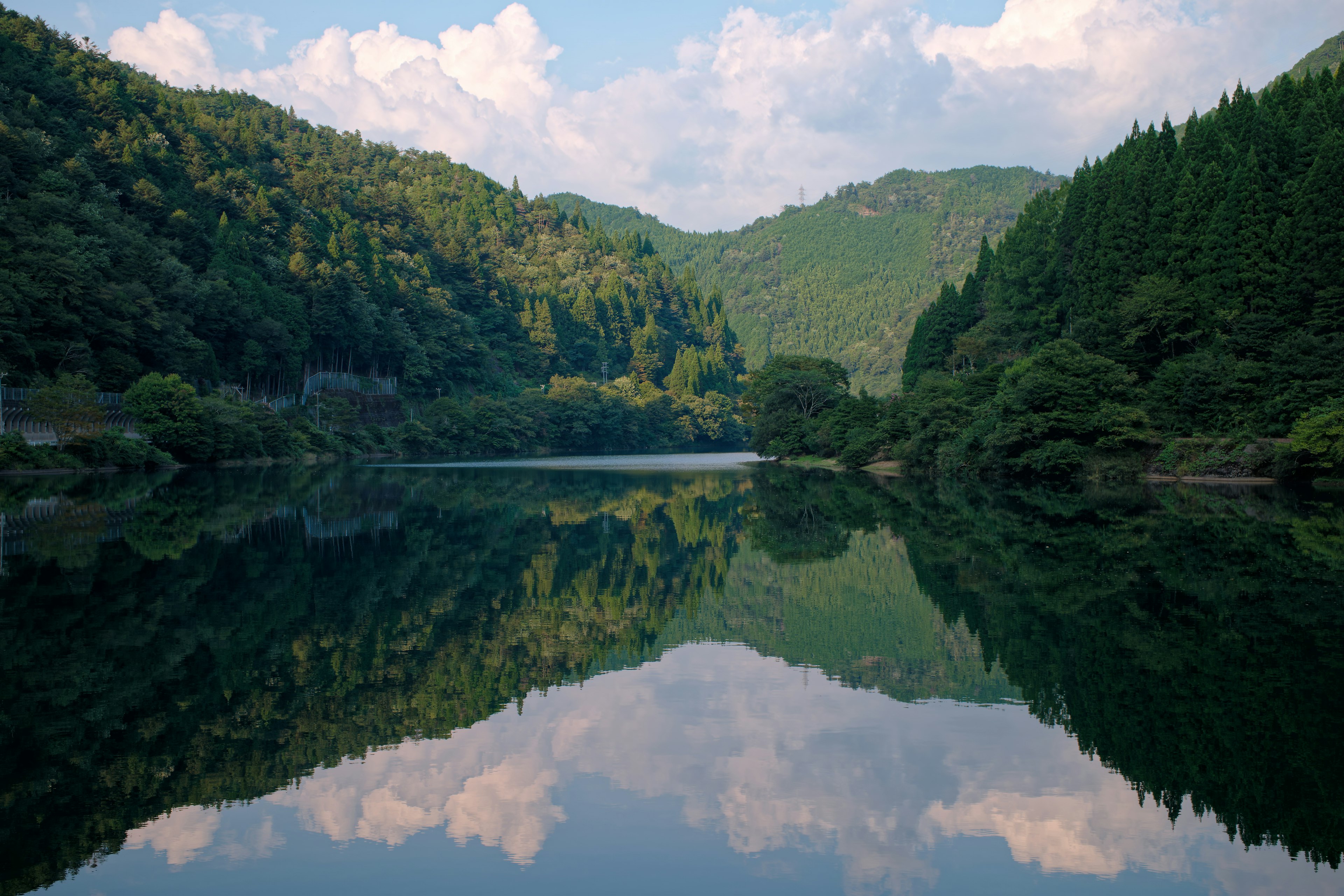 Lago sereno con montagne verdi che si riflettono nell'acqua