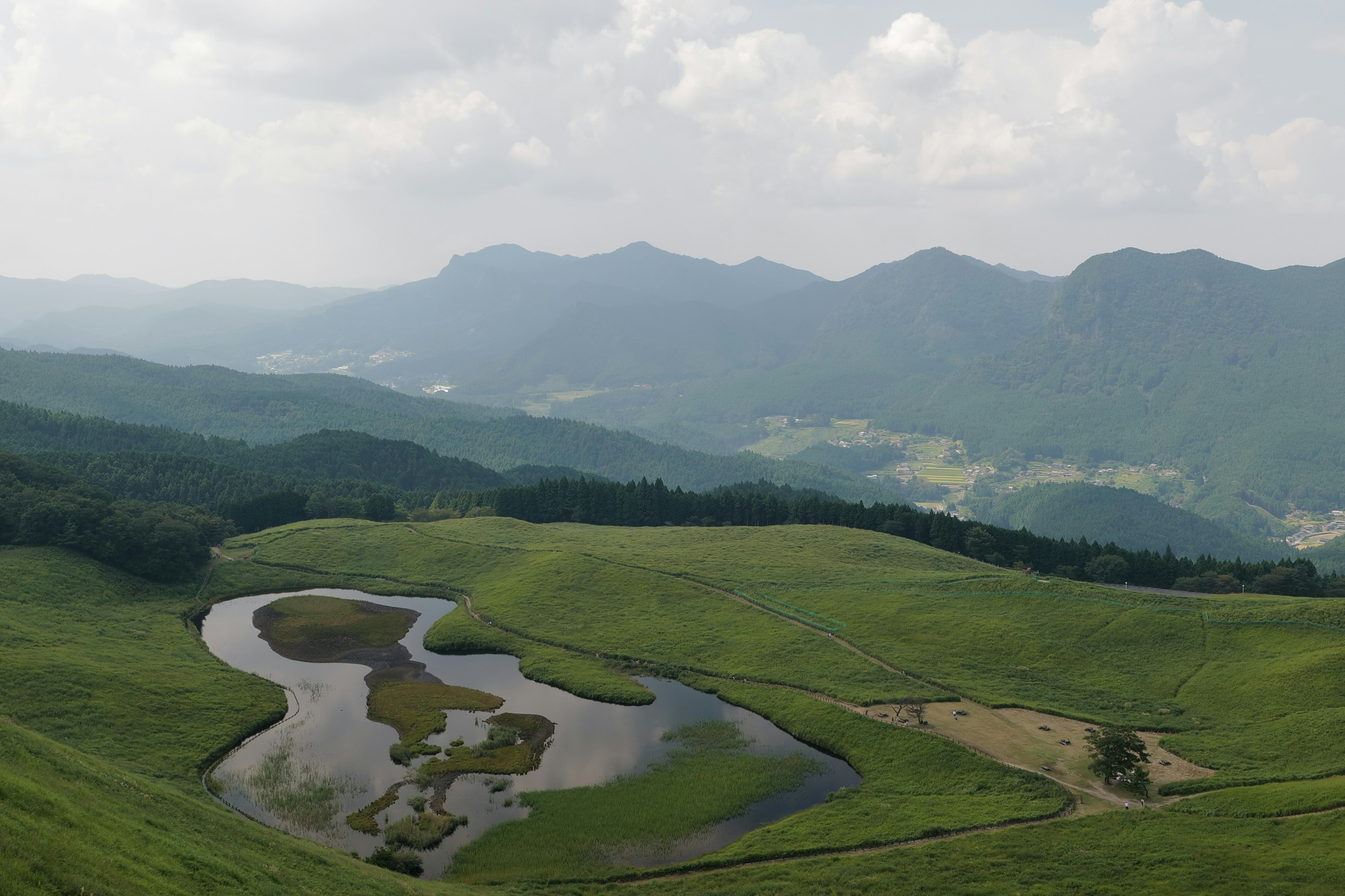 美しい緑の丘と静かな池が広がる風景