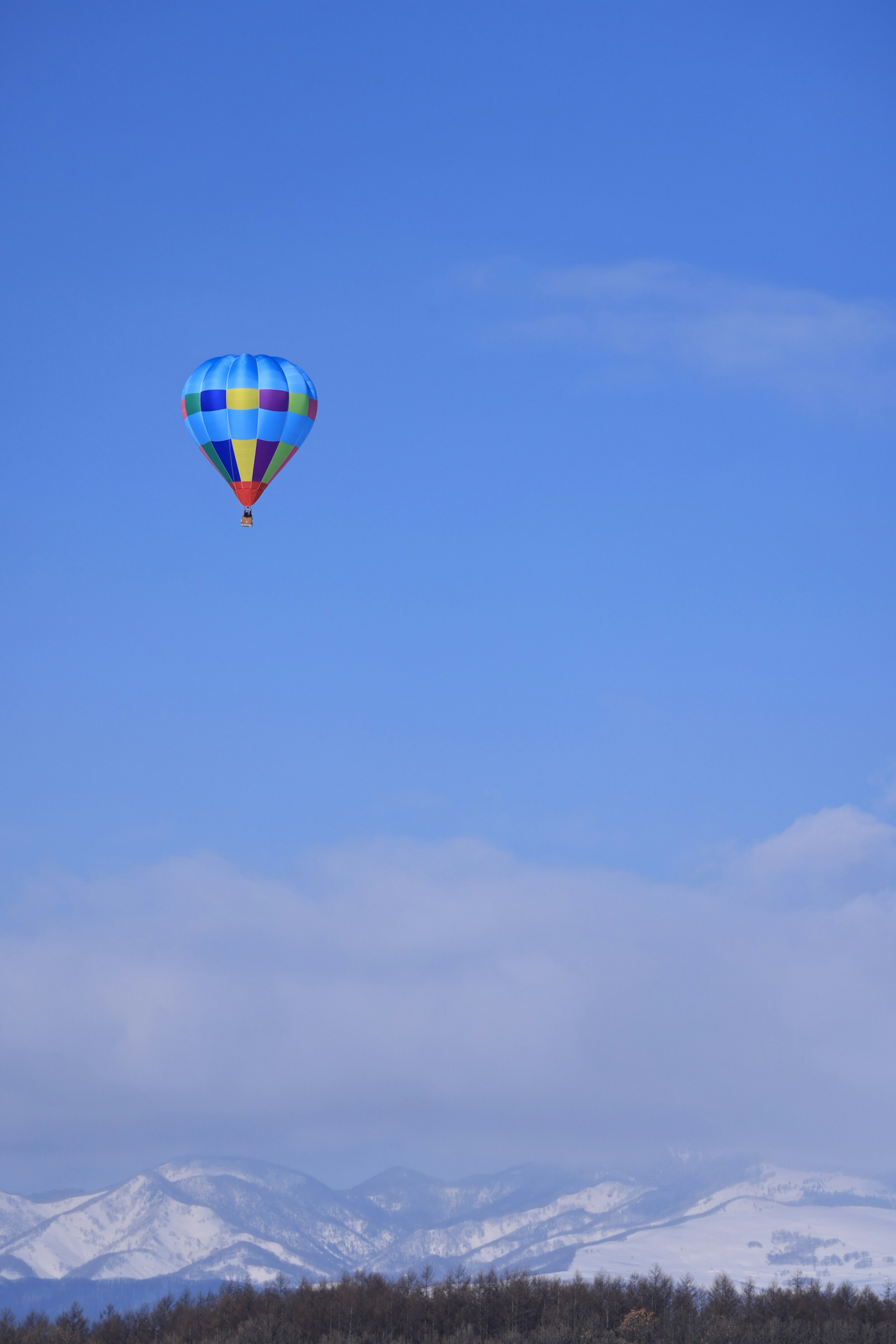 Montgolfière colorée flottant dans le ciel bleu