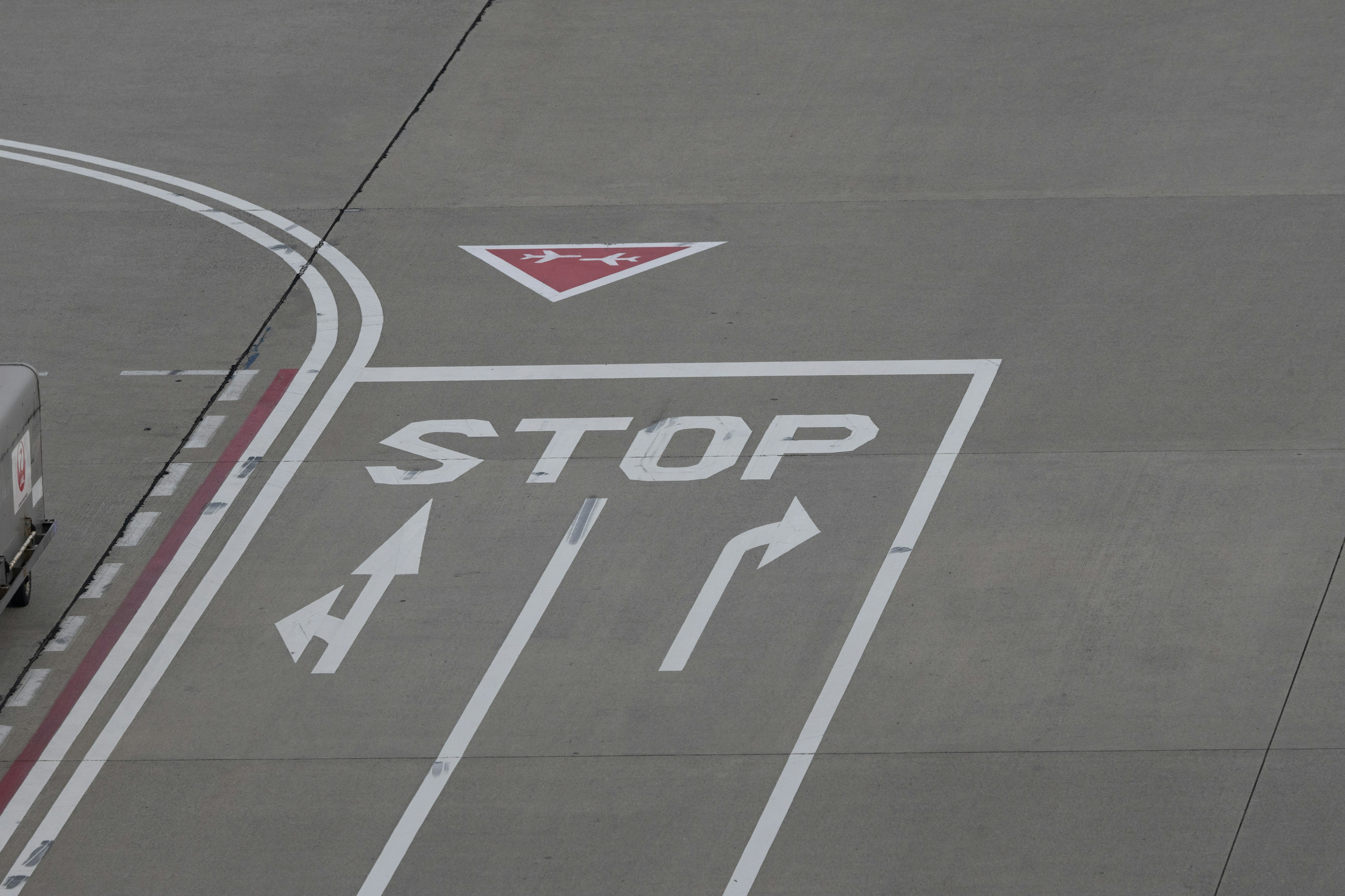 Aerial view of a stop sign and directional arrows on a pavement