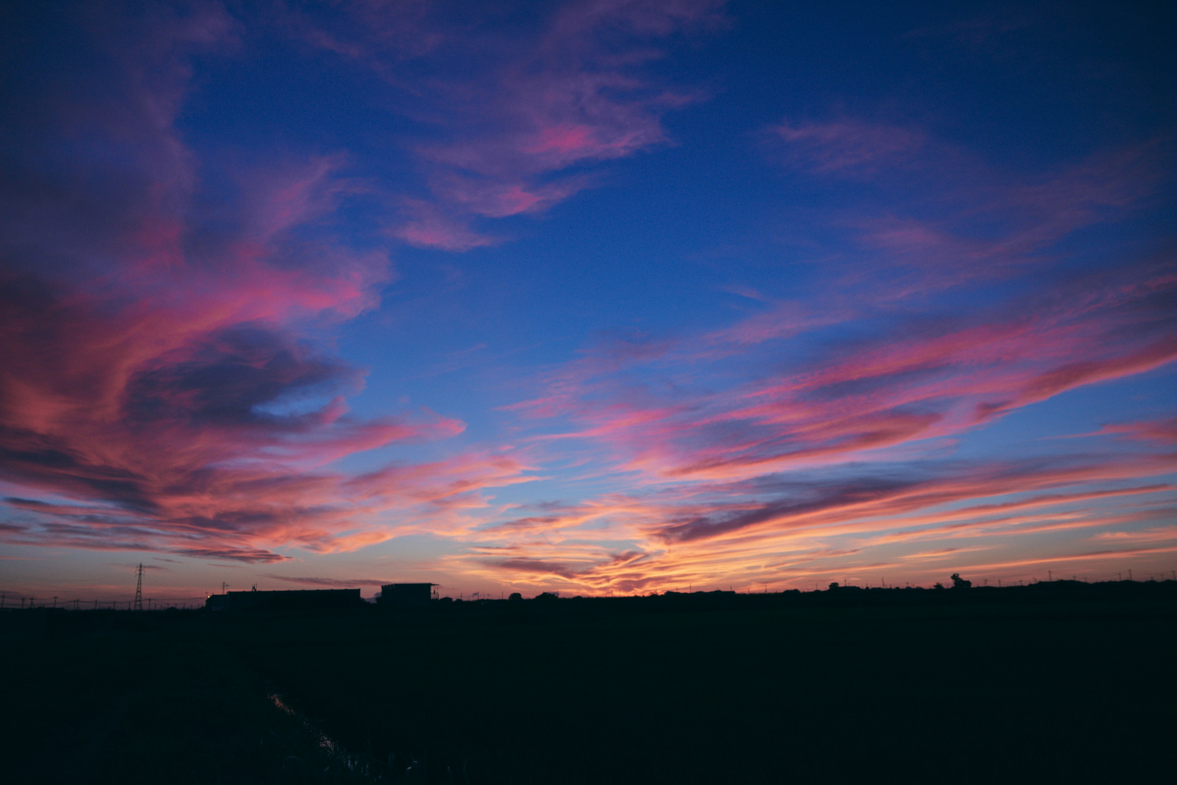 美しい夕焼けの空にピンクと青の雲が広がる