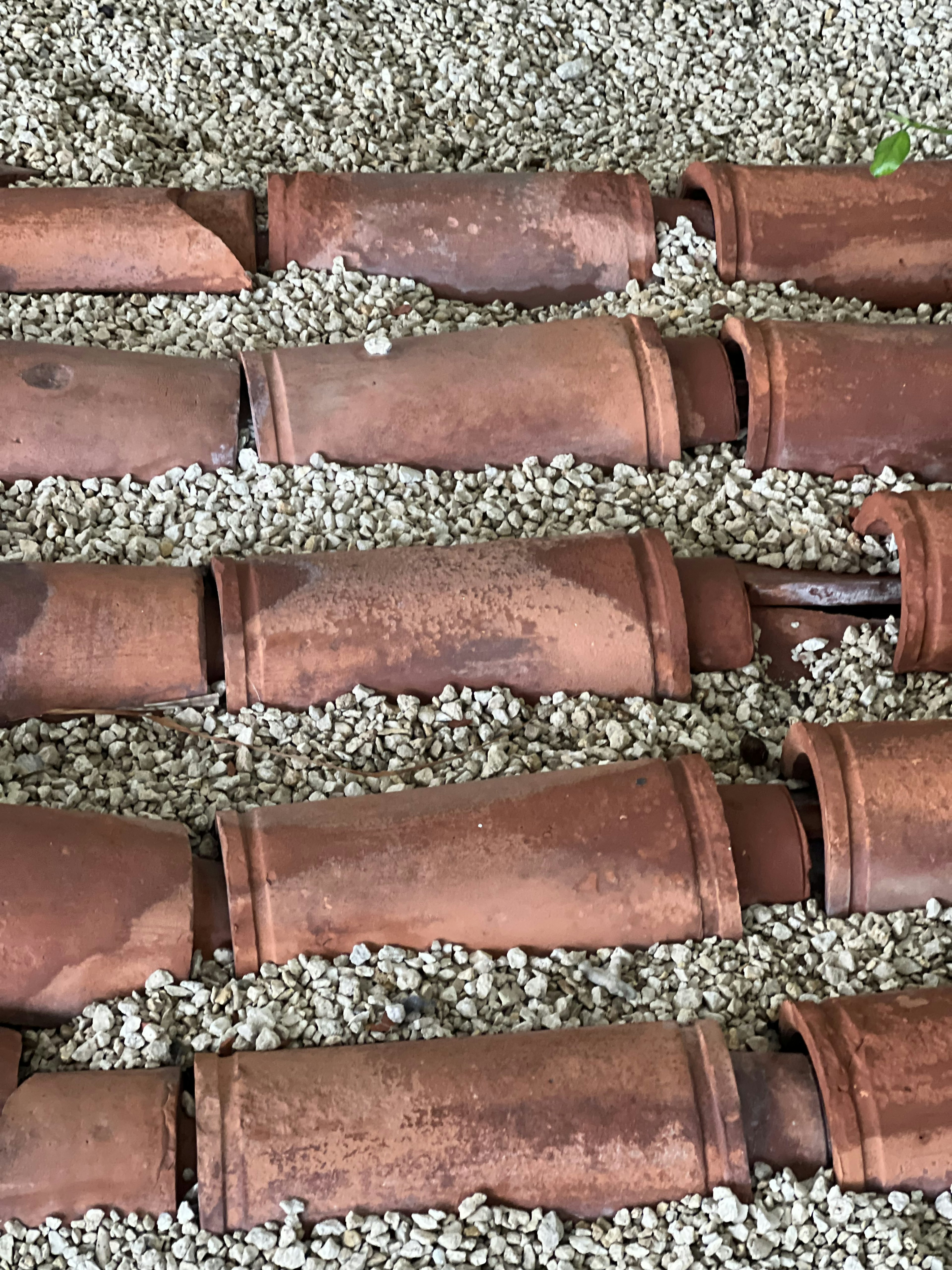 Clay pipes arranged over gravel