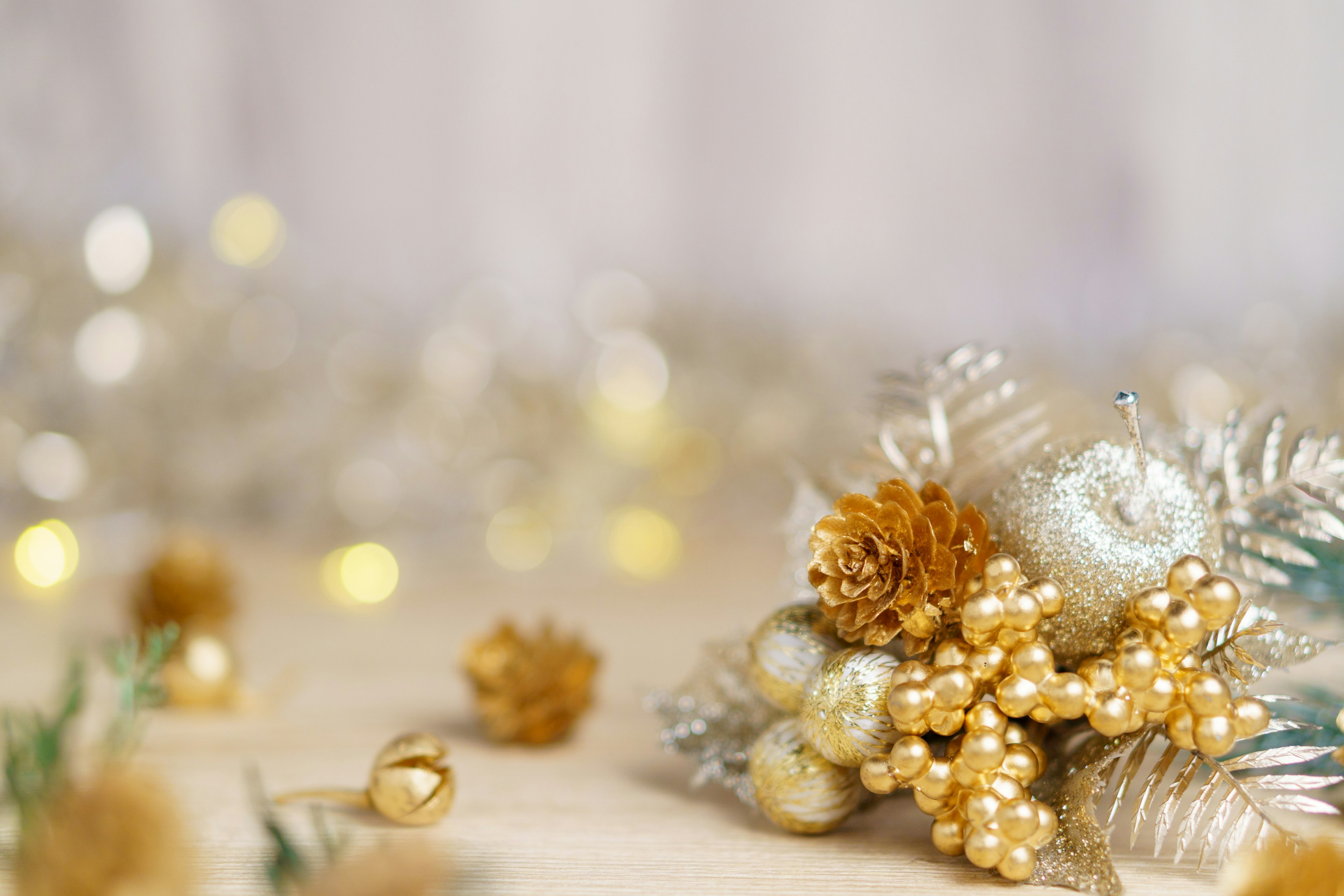 Weihnachtliche Tischdekoration mit goldenen Ornamenten und Pflanzen