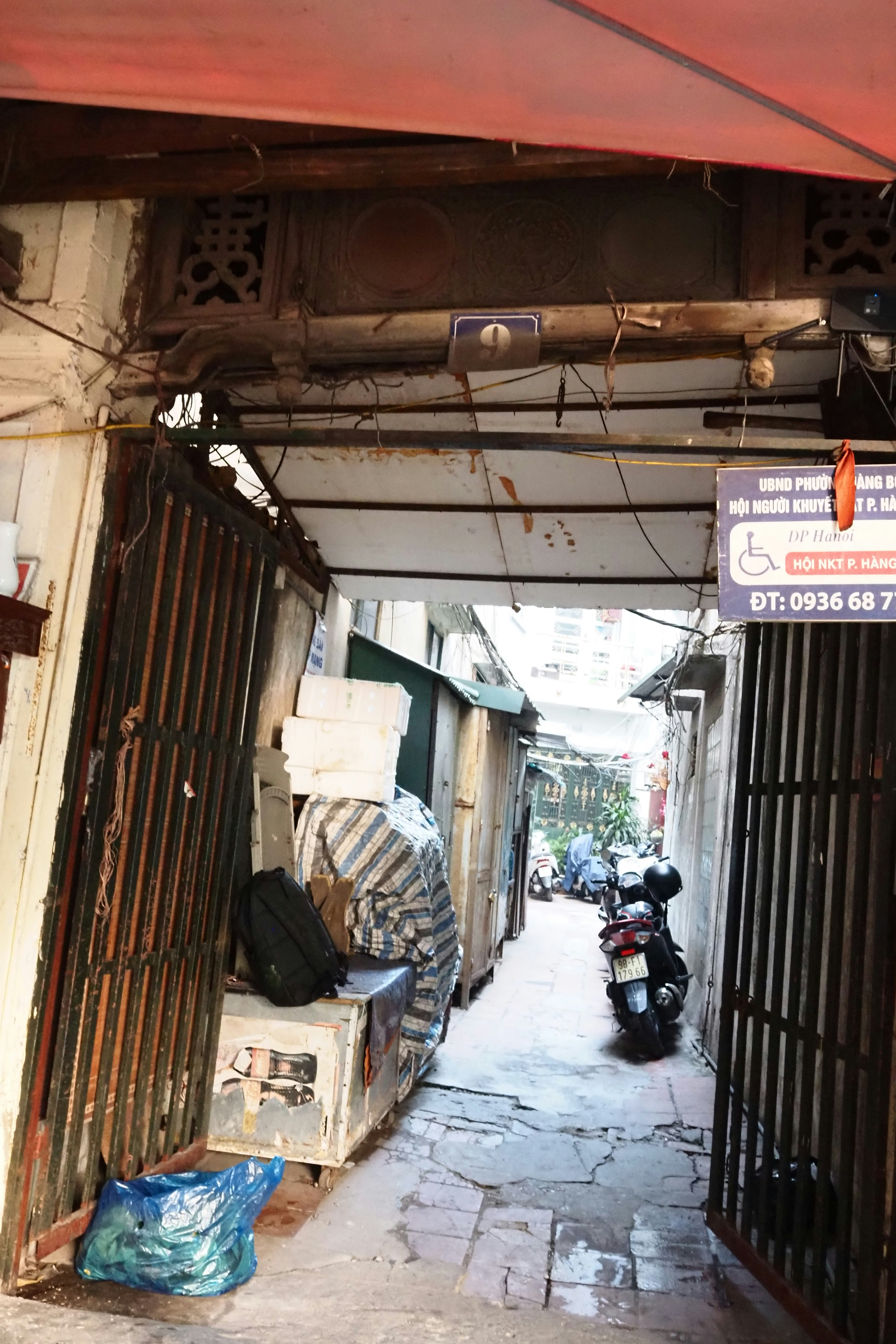 Eingang zu einer schmalen Gasse mit Toren und einem Motorrad