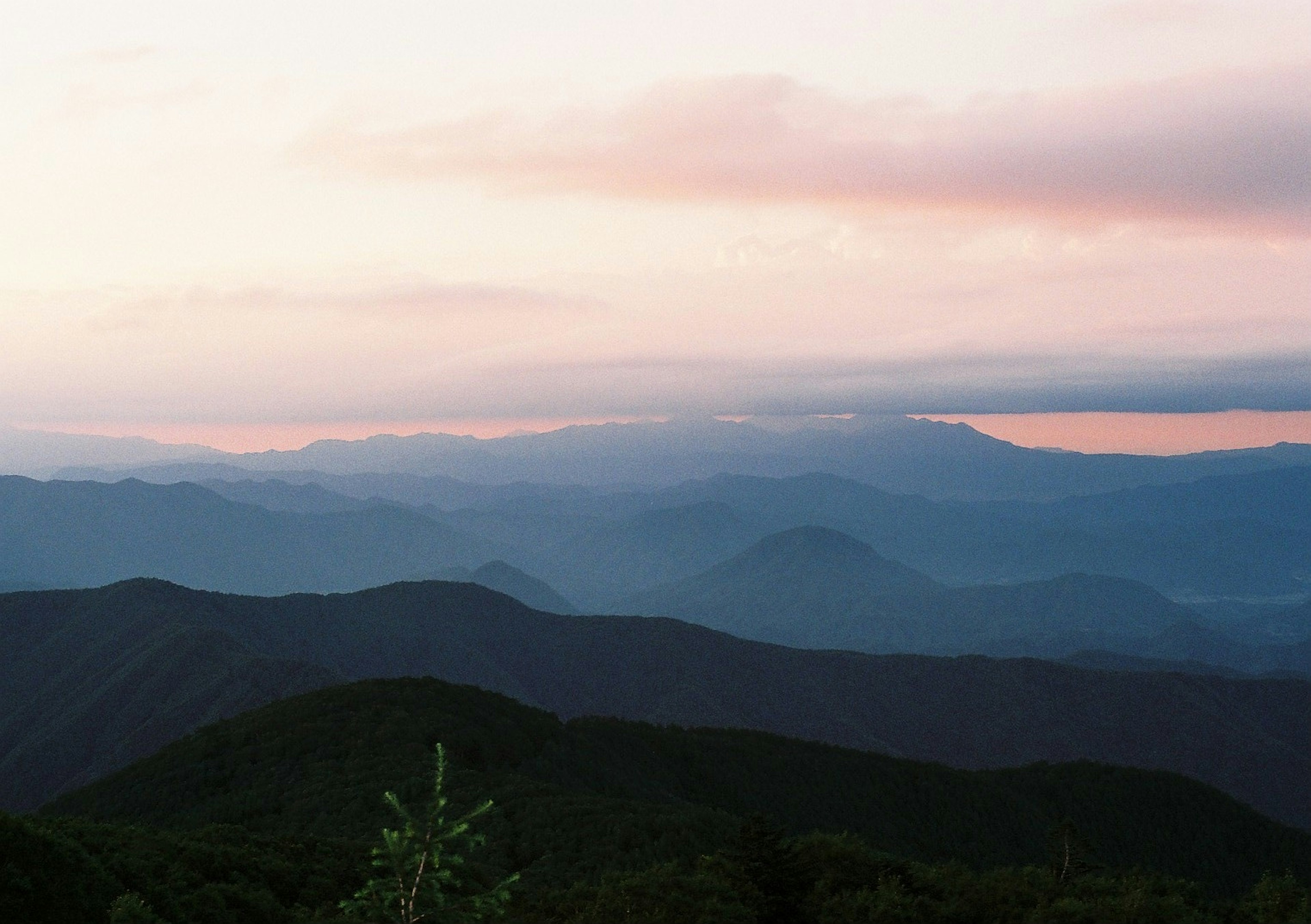 Vista panoramica di montagne con colori morbidi al tramonto