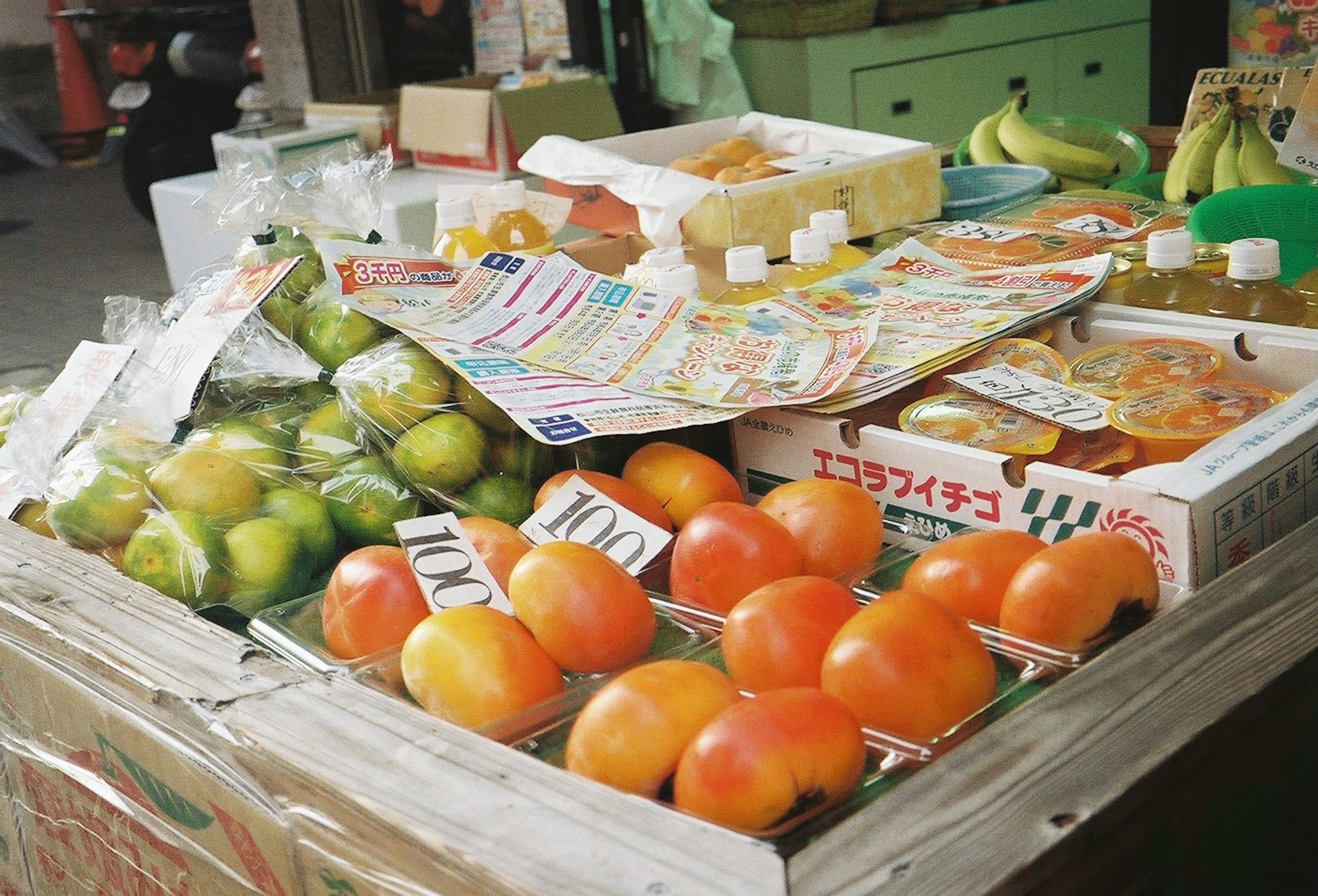 Un colorido puesto de frutas que exhibe varias frutas y empaques coloridos