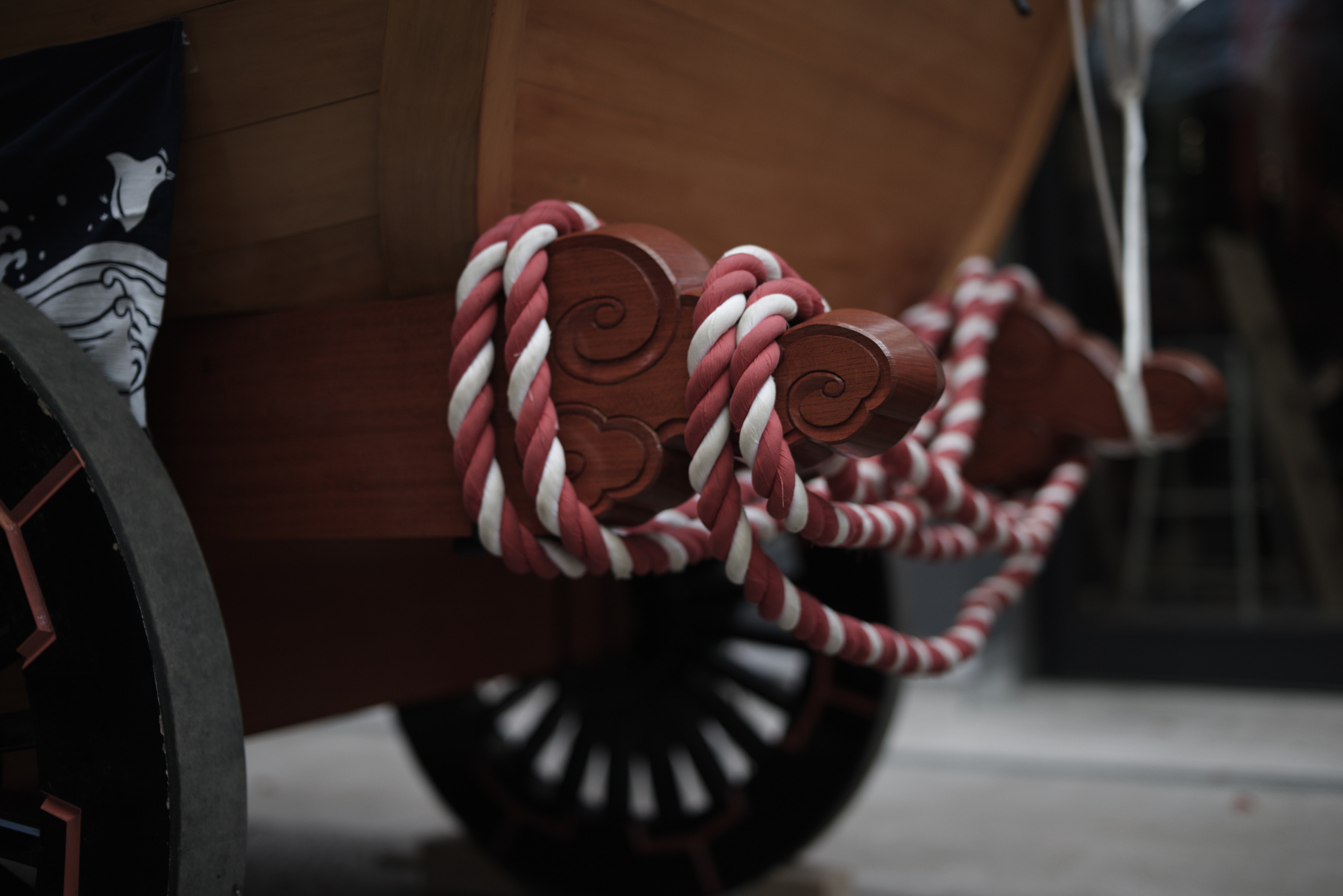 Wooden cart featuring red and white decorative rope