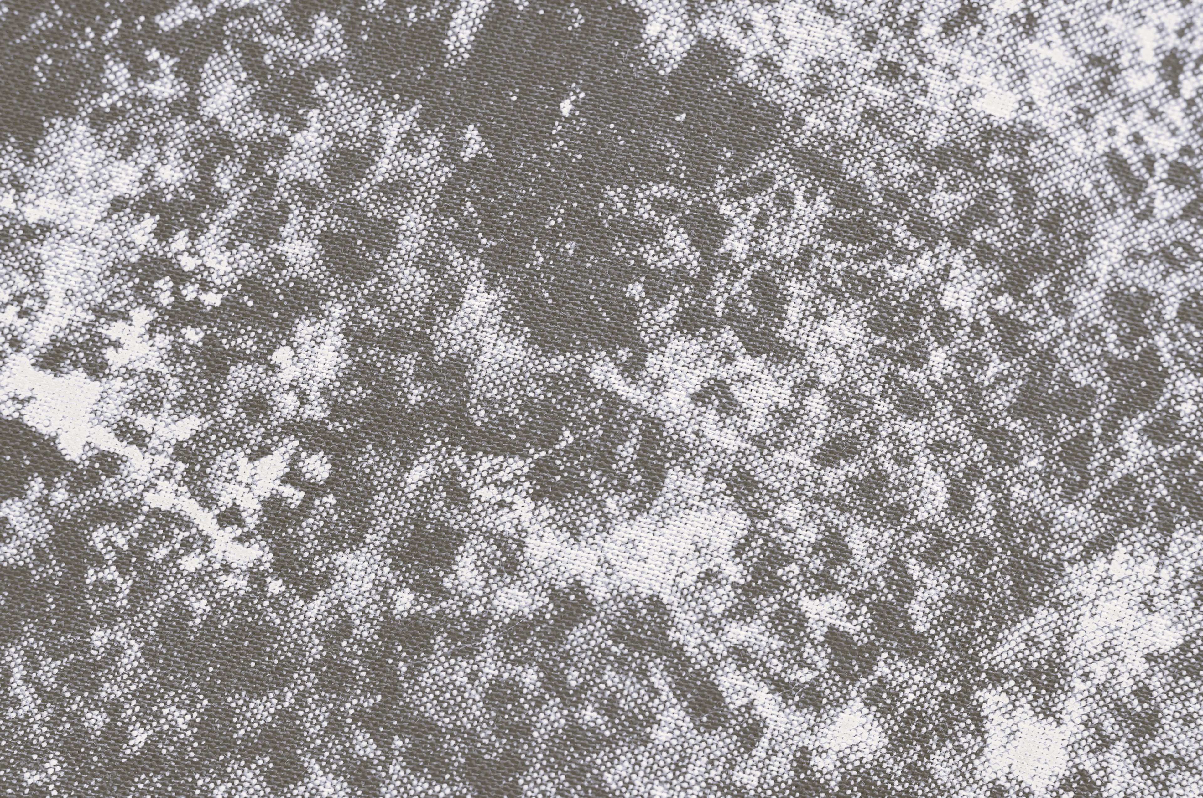 Abstract image with a textured gray background and white powdery patterns